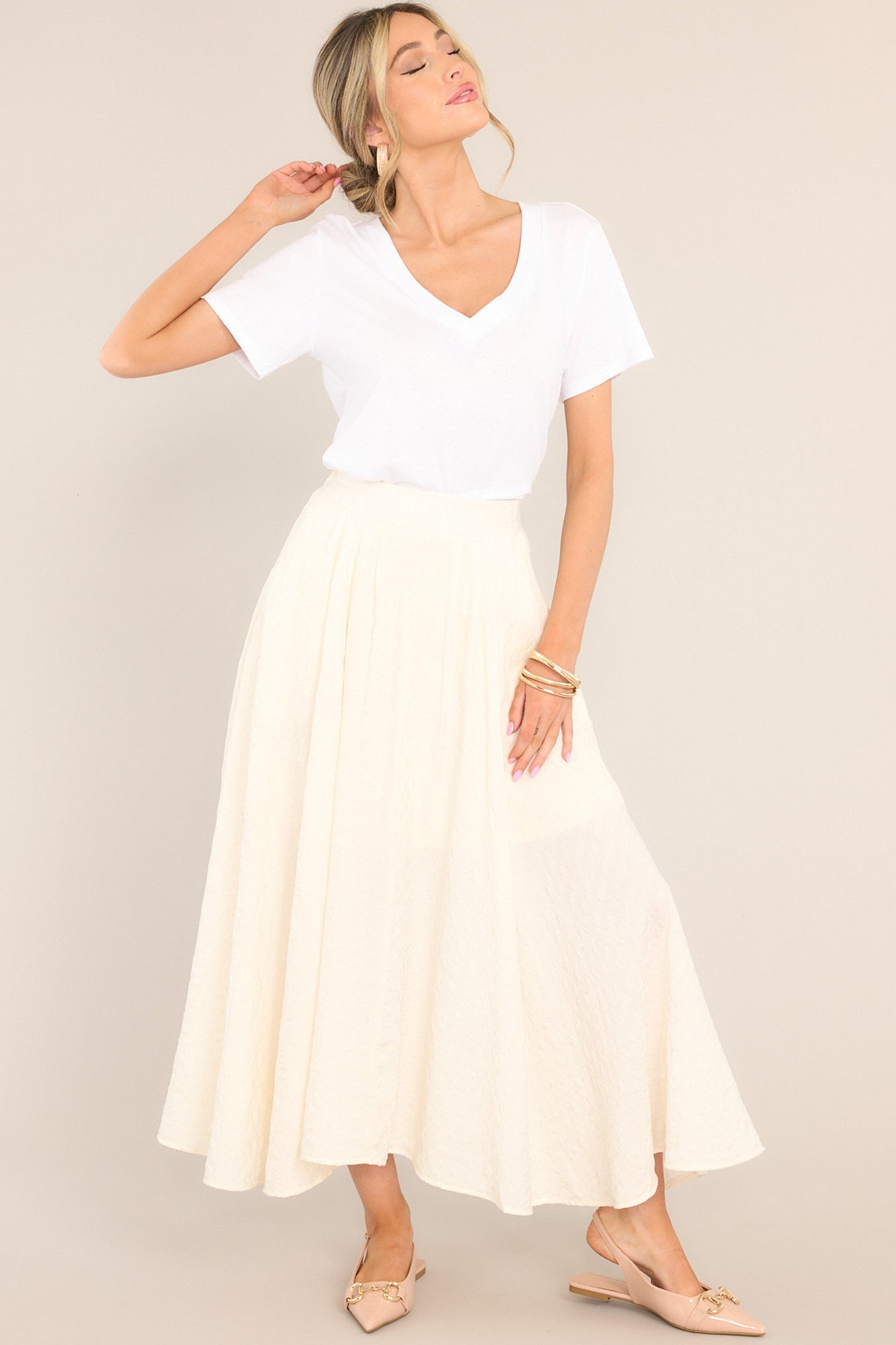 This white skirt features a high waisted design, an elastic insert at the back of the waist, a subtle shimmering hue, functional pockets, and a lot of flowing fabric.