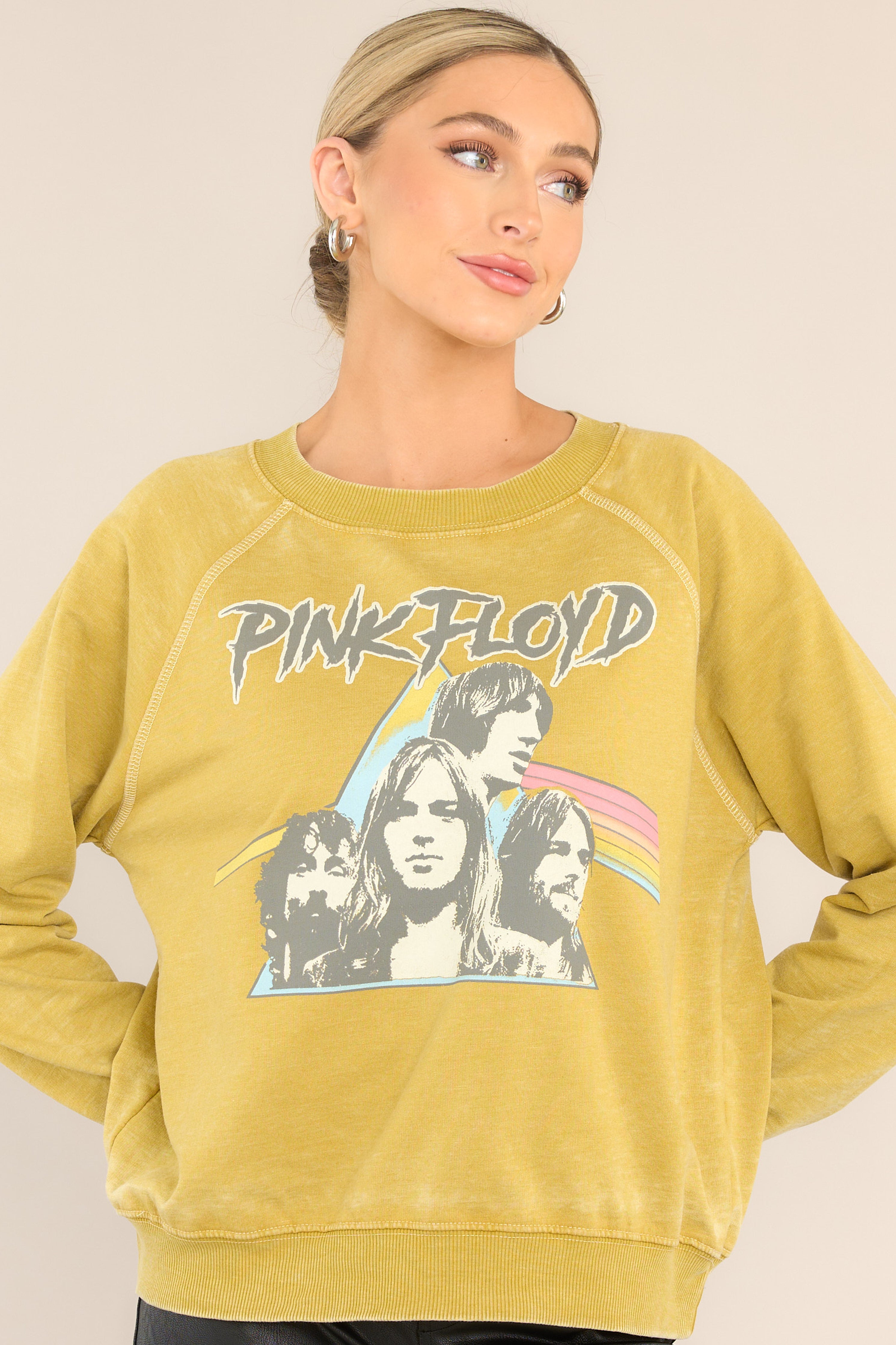 Front view of  this sweatshirt that features a ribbed crew neckline, exposed seams, graphic of the band members, "Dark Side of The Moon" album cover art, cuffed