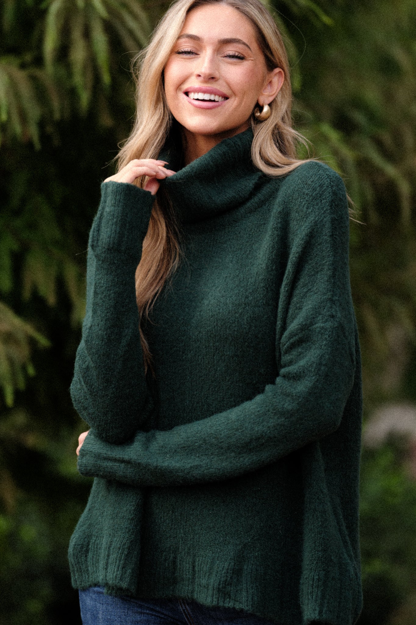 This hunter green sweater features a very light eyelash knit design, a turtle cowl neckline, extremely dropped shoulders, and a slight high low hemline.