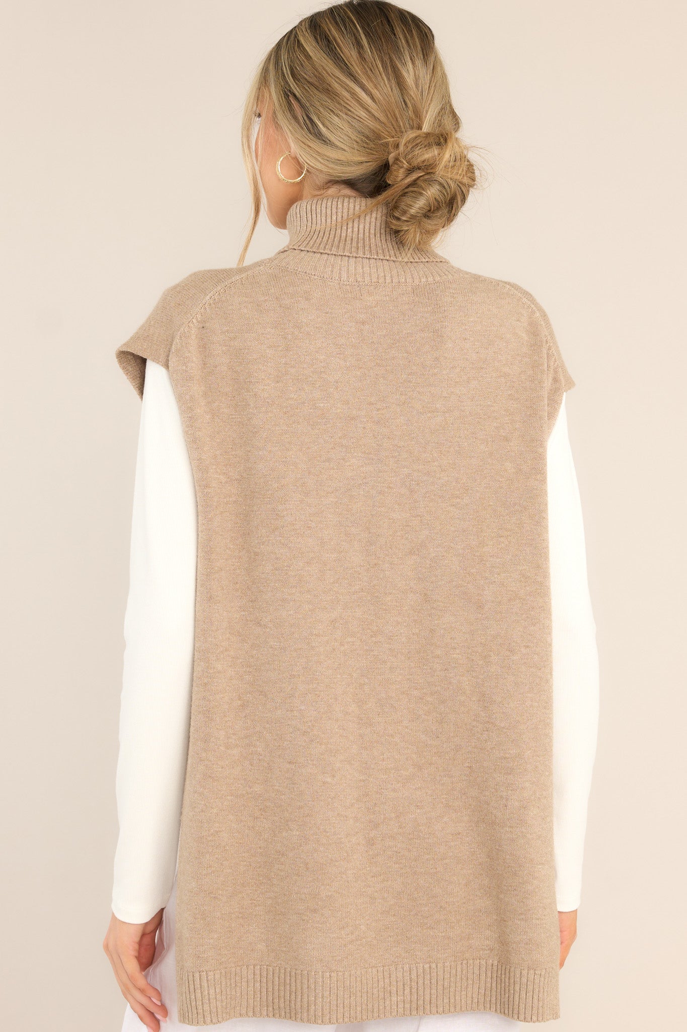 Back view of this sweater vest that features a relaxed-fit, turtleneck, rib-knit fabric throughout, slits at sides of hem and longer at back.