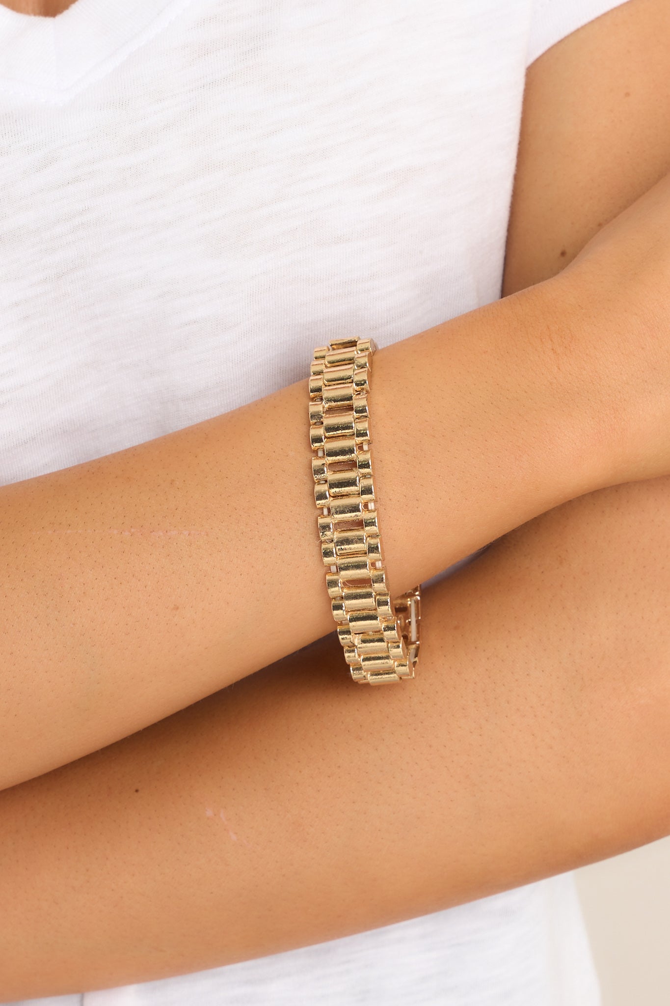 Close up view of this bracelet that features gold hardware, watch style band, stretch band, and a slip-on style.