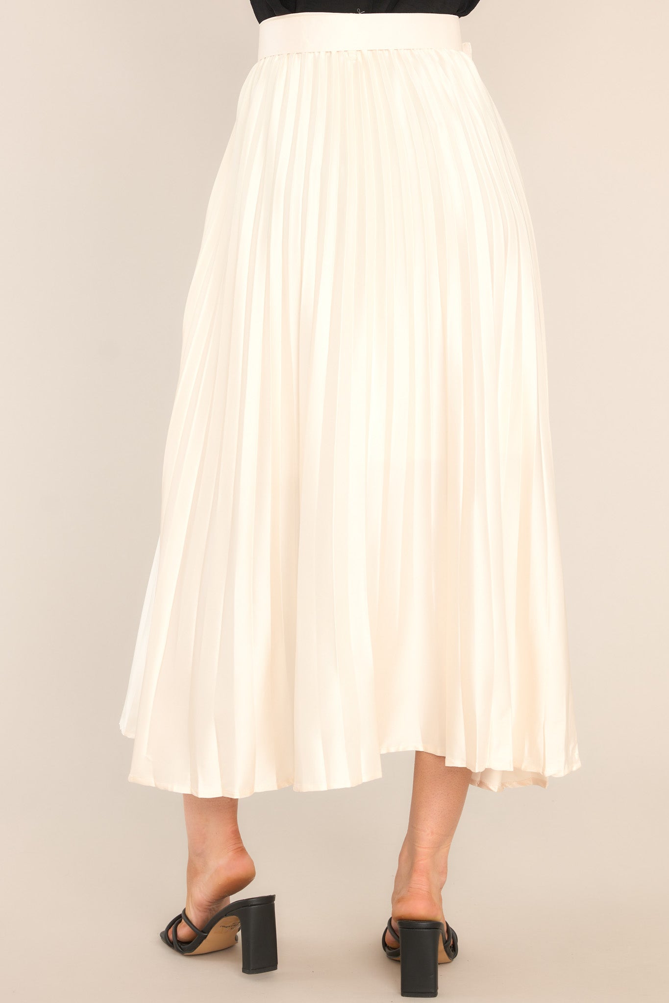 Back view of this maxi skirt that features a high waisted design, a side zipper, belt loops, a functional and removable belt, and pleats throughout.