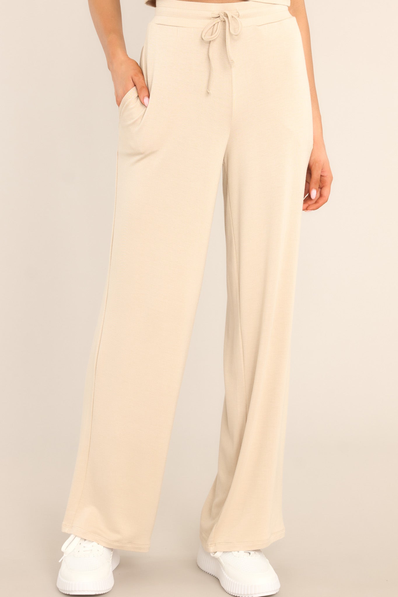 Front view of these pants that feature a high waisted design, a self-tie drawstring, functional pockets, and a wide leg.