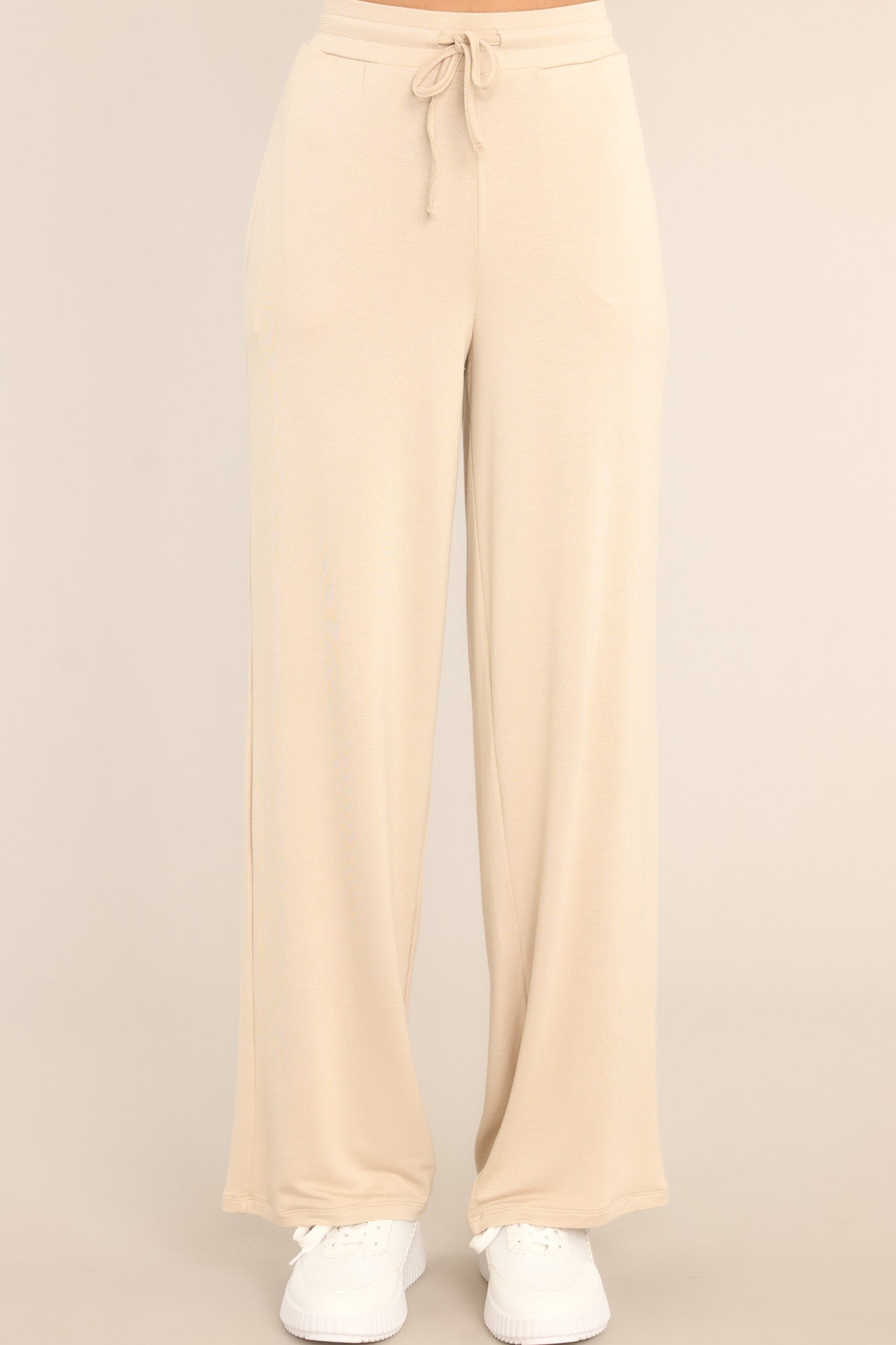 Close up view of these pants that feature a high waisted design, a self-tie drawstring, functional pockets, and a wide leg.