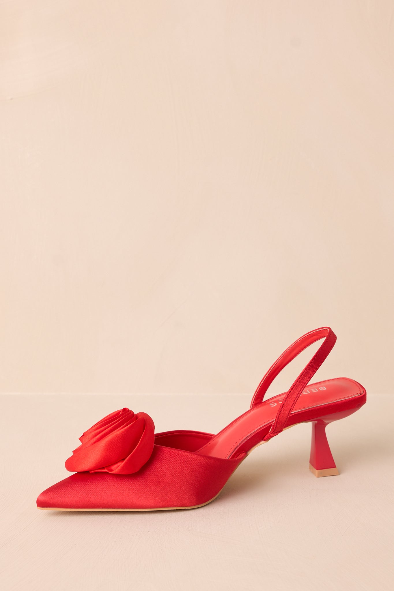 Another side shot of the red heel displaying the slim slingback strap and kitten heel design.
