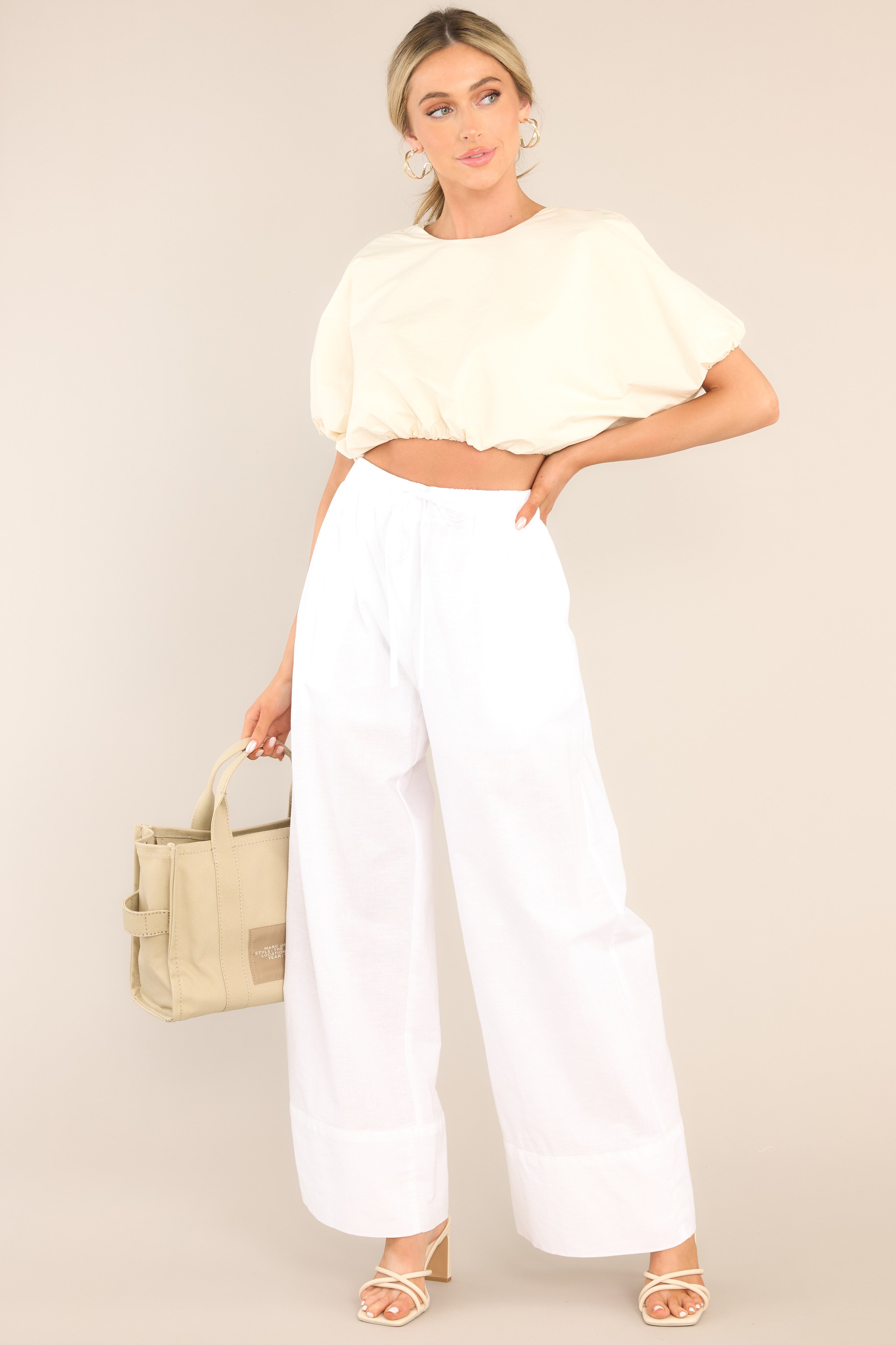 Full body view of this top that features a crew neckline, elastic cuffed dolman sleeves, and an elastic cuffed cropped hemline.