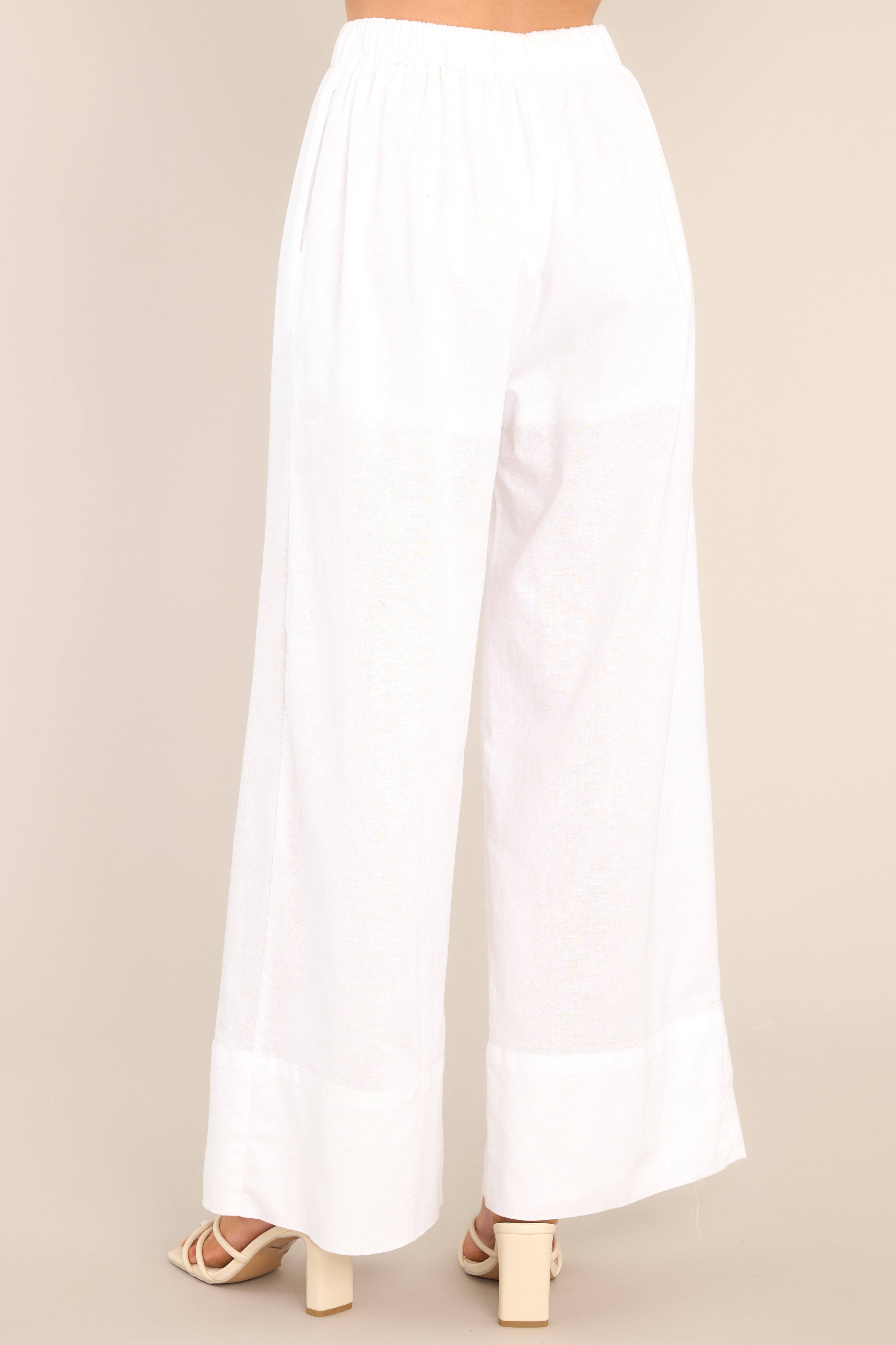 Back view of these pants that feature a high waisted design, an elastic waistband with a self-tie feature, functional pockets, and a thick ankle cuff. 