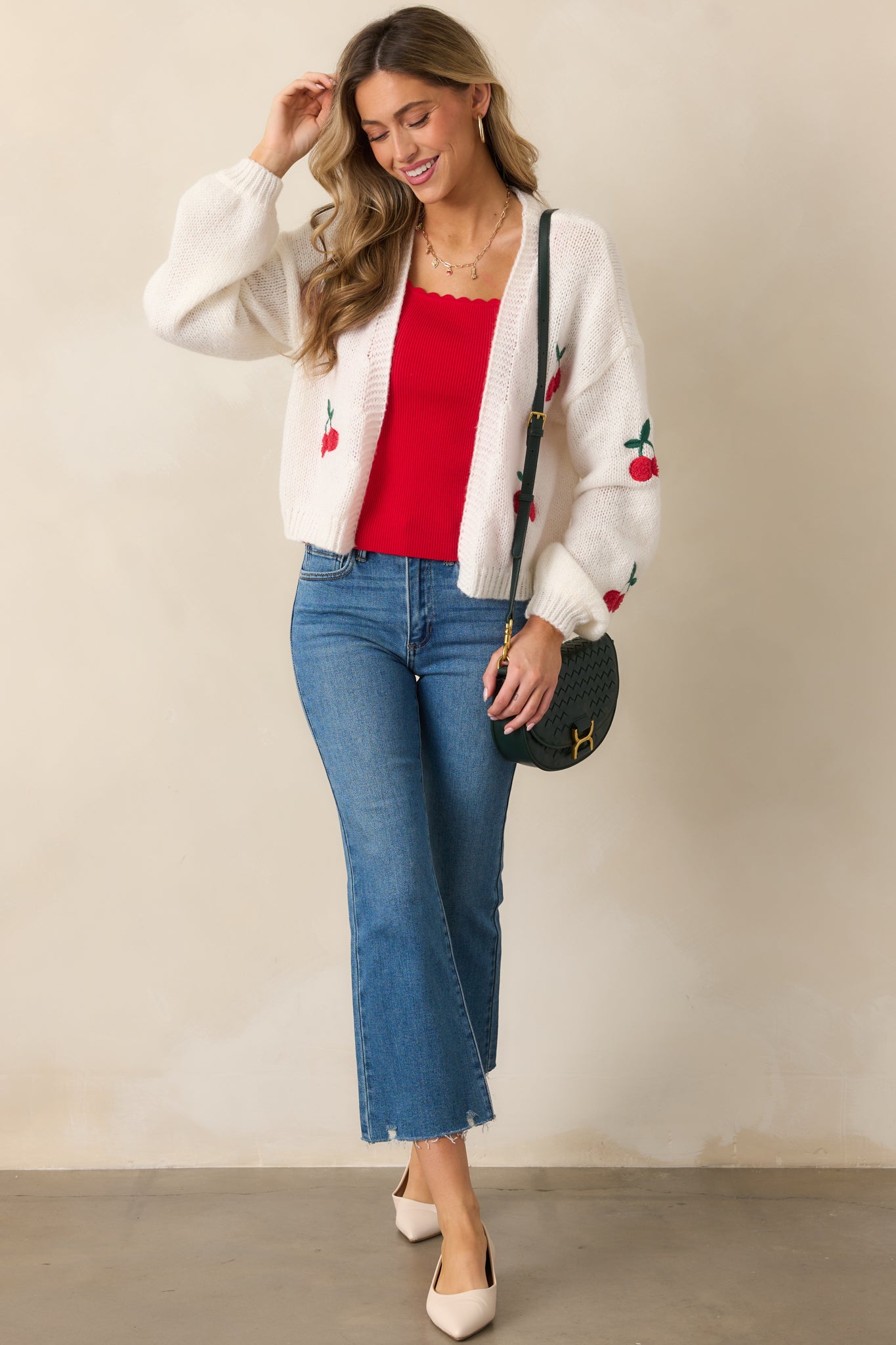 The cardigan shown from a full-length view, emphasizing the drape of the ribbed fabric, the comfortable long sleeves, and the placement of the cherry decals.