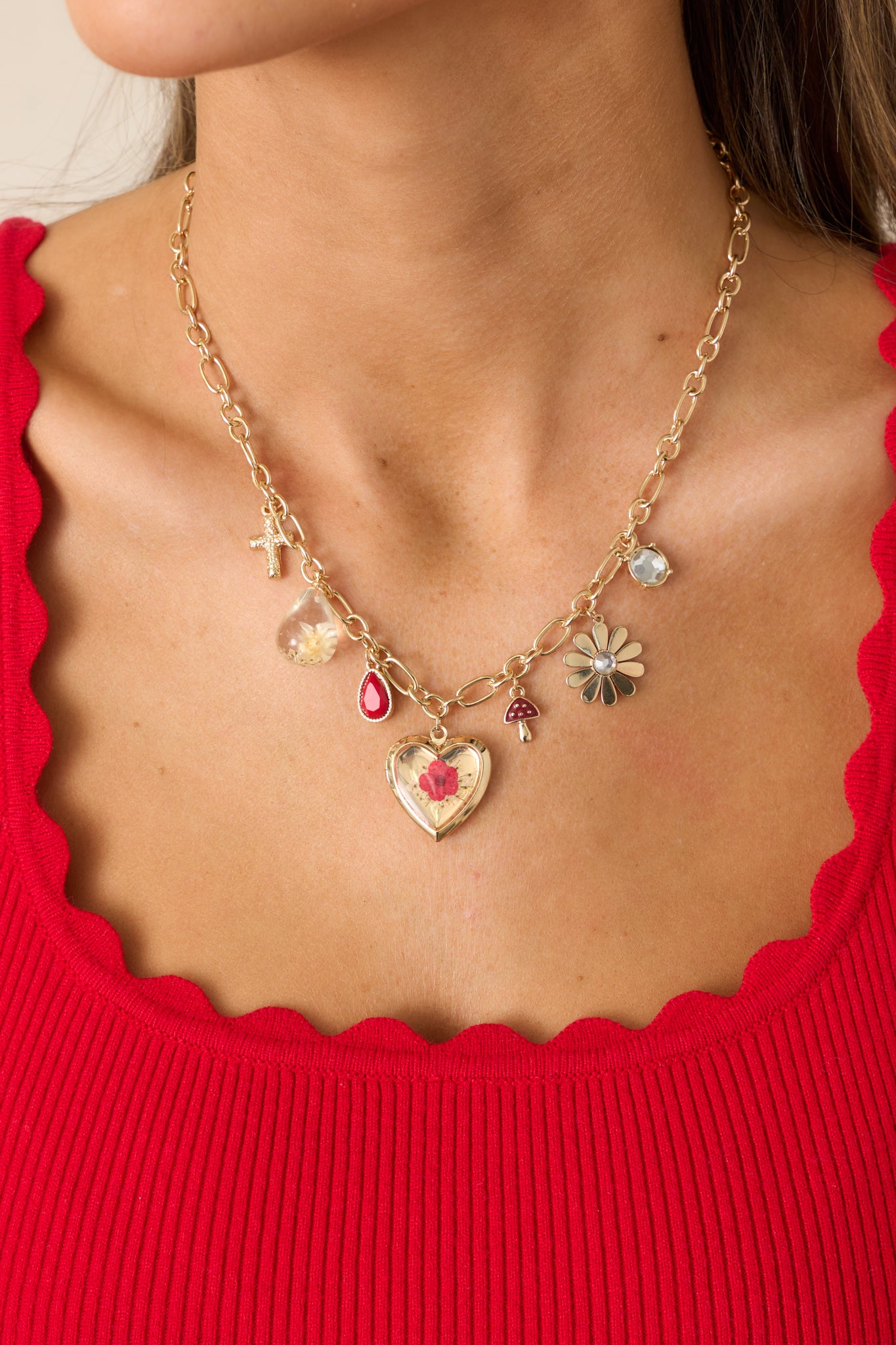 A detailed image highlighting the flower pendant, flower in resin charm, and the variety of gold charms connected by gold jump rings.