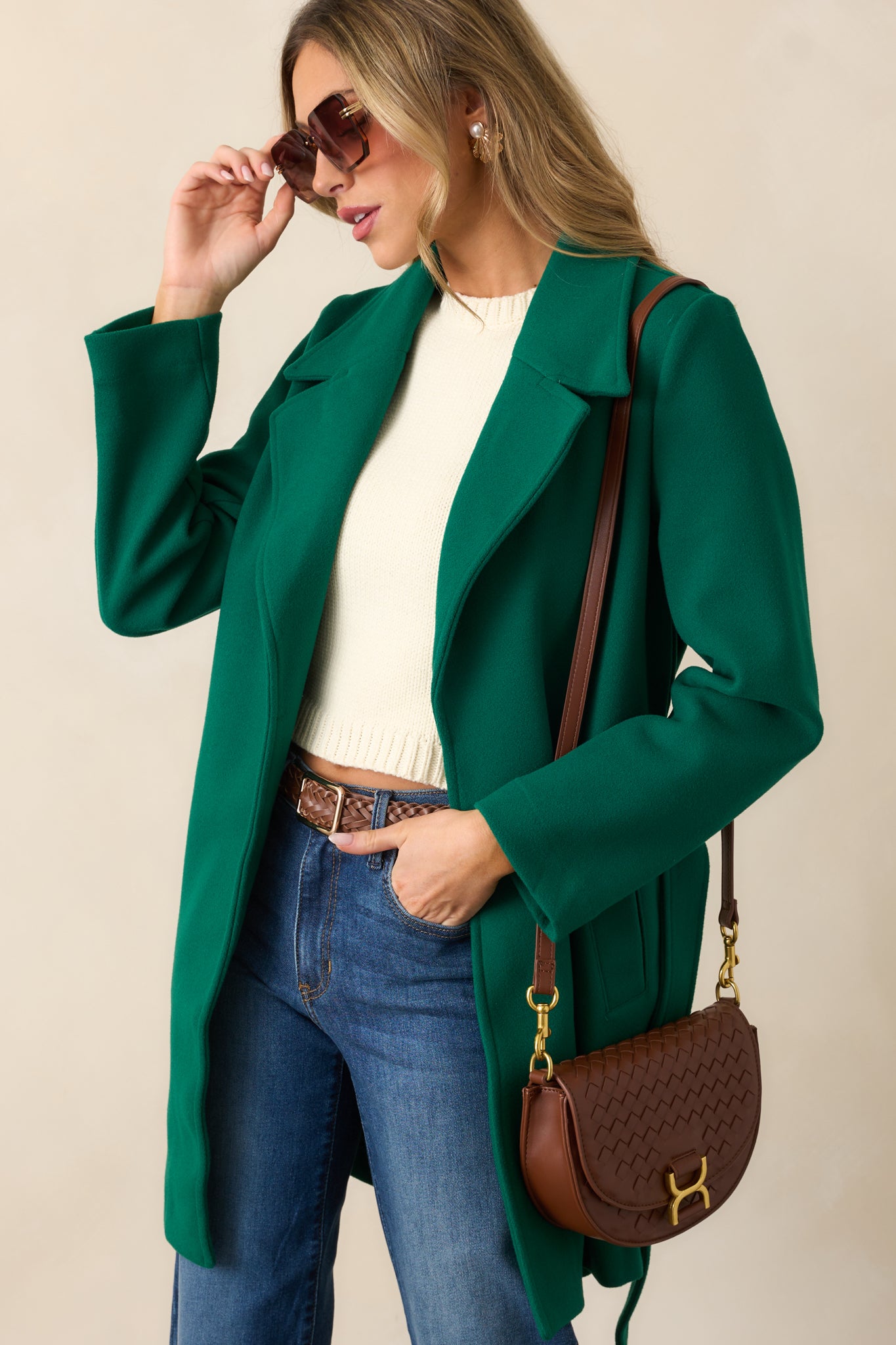 The kelly green coat displayed with the self-tie waistband hanging loose, highlighting the clean and structured double-breasted silhouette.