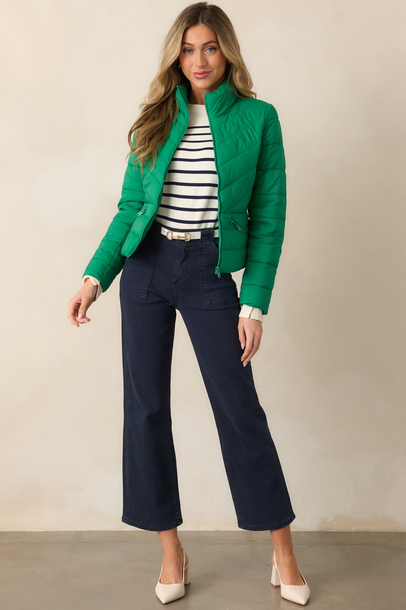 Another full-body shot showcasing the navy jeans with their high-waisted silhouette and functional large front pockets, button and zipper closure, and sleek fit.