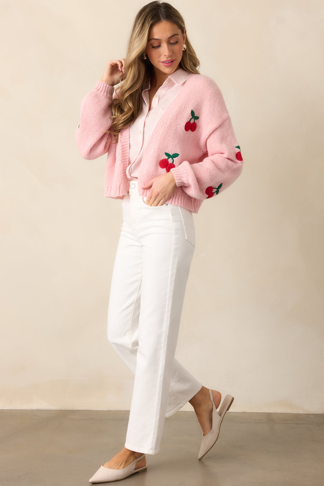 A side profile of the light pink cardigan, emphasizing the ribbed texture and the flow of the open-front design.