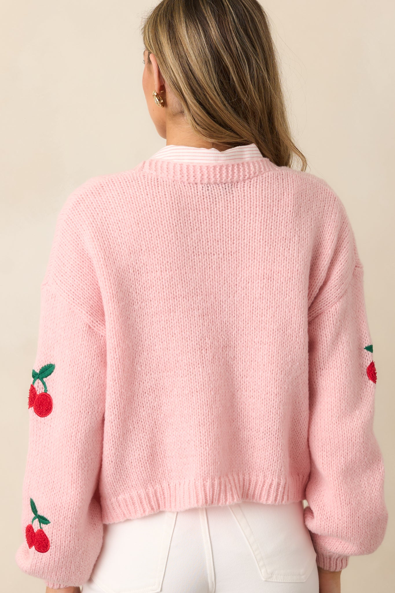 A back view of the cardigan, showcasing the solid light pink back and the continuation of the ribbed texture.