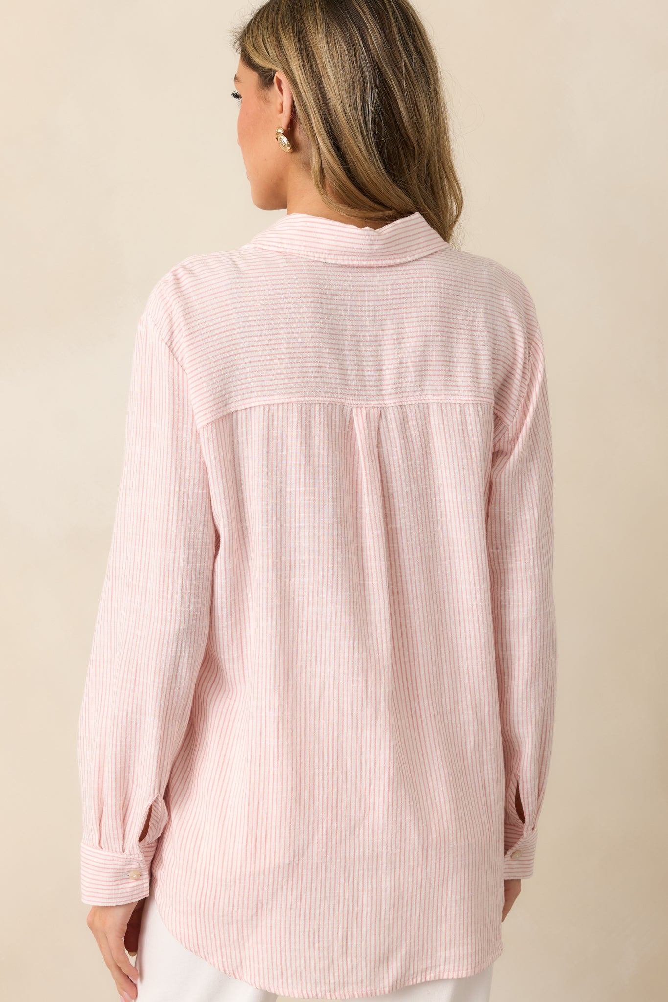 A back view of the pink top, showcasing the continuous stripe print and relaxed fit of the light linen blend fabric.