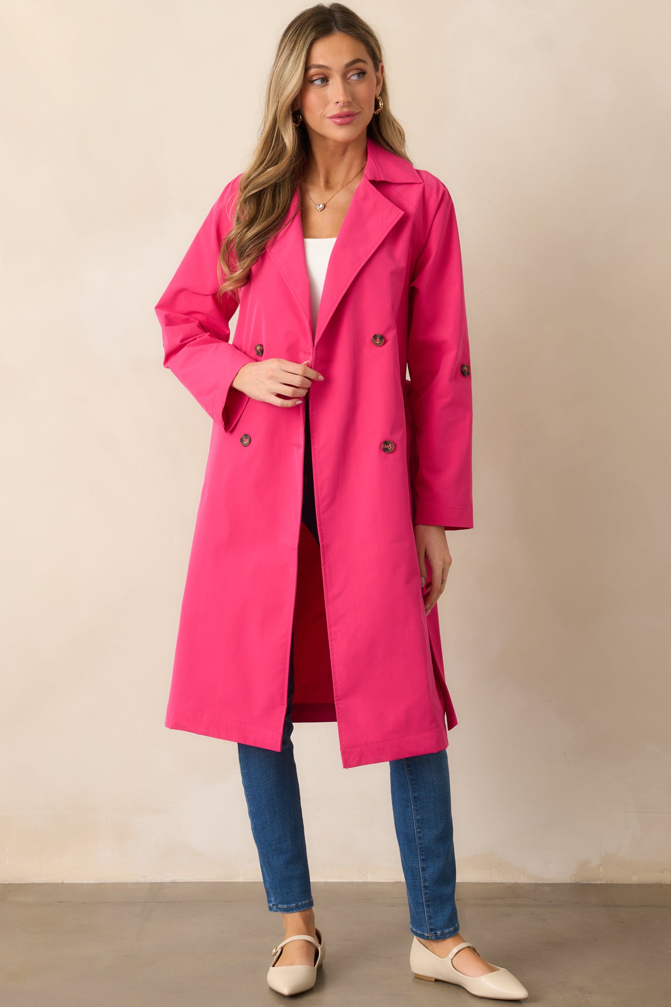 The magenta coat shown untied, emphasizing the collared neckline, double-breasted lapel design, and the flow of the long sleeves.