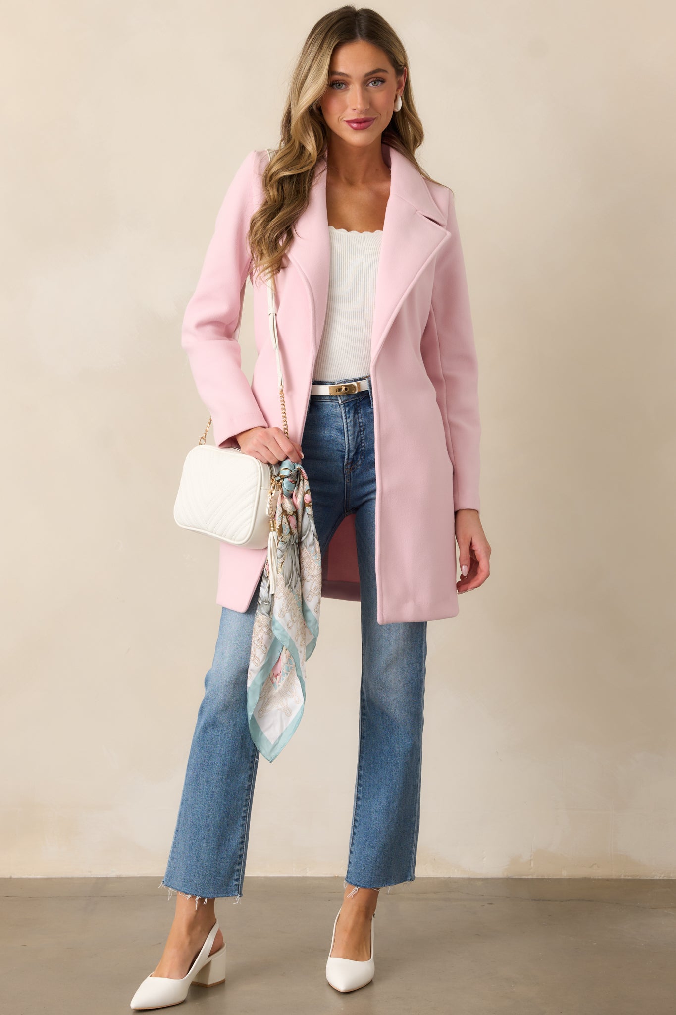 A complete look of the light pink coat, showcasing the front buttons, self-tie waistband, and long sleeve details.