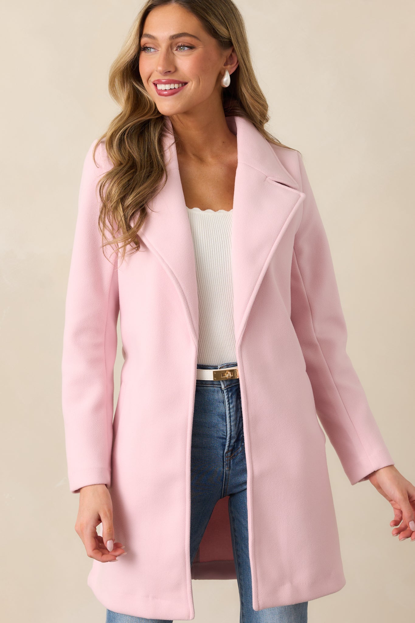 A detailed front view of the upper section of the light pink coat, emphasizing the lapels and double-breasted button arrangement.