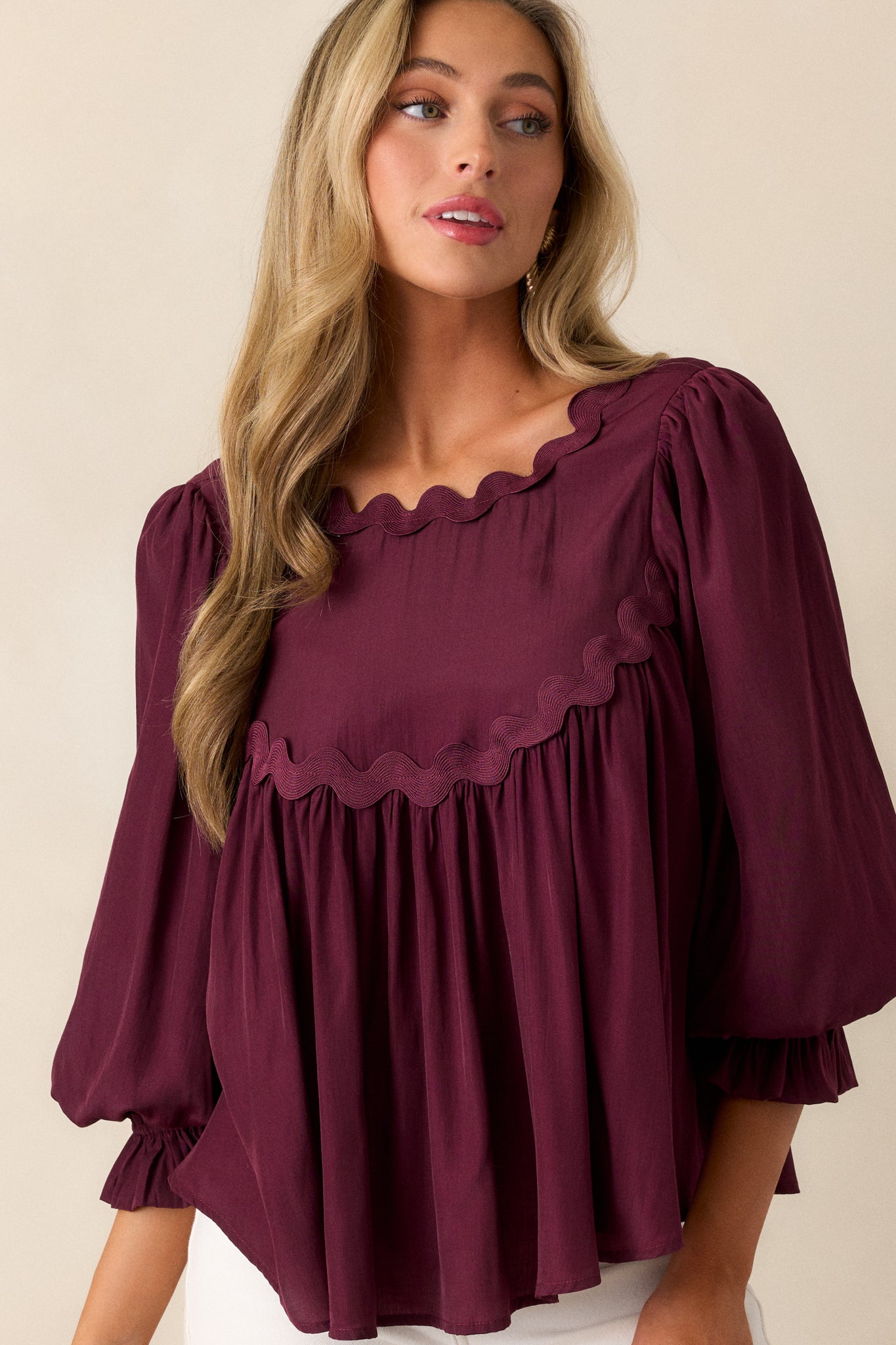 Close-up of the scalloped neckline and single back button on the dark sangria top, highlighting its elegant design.