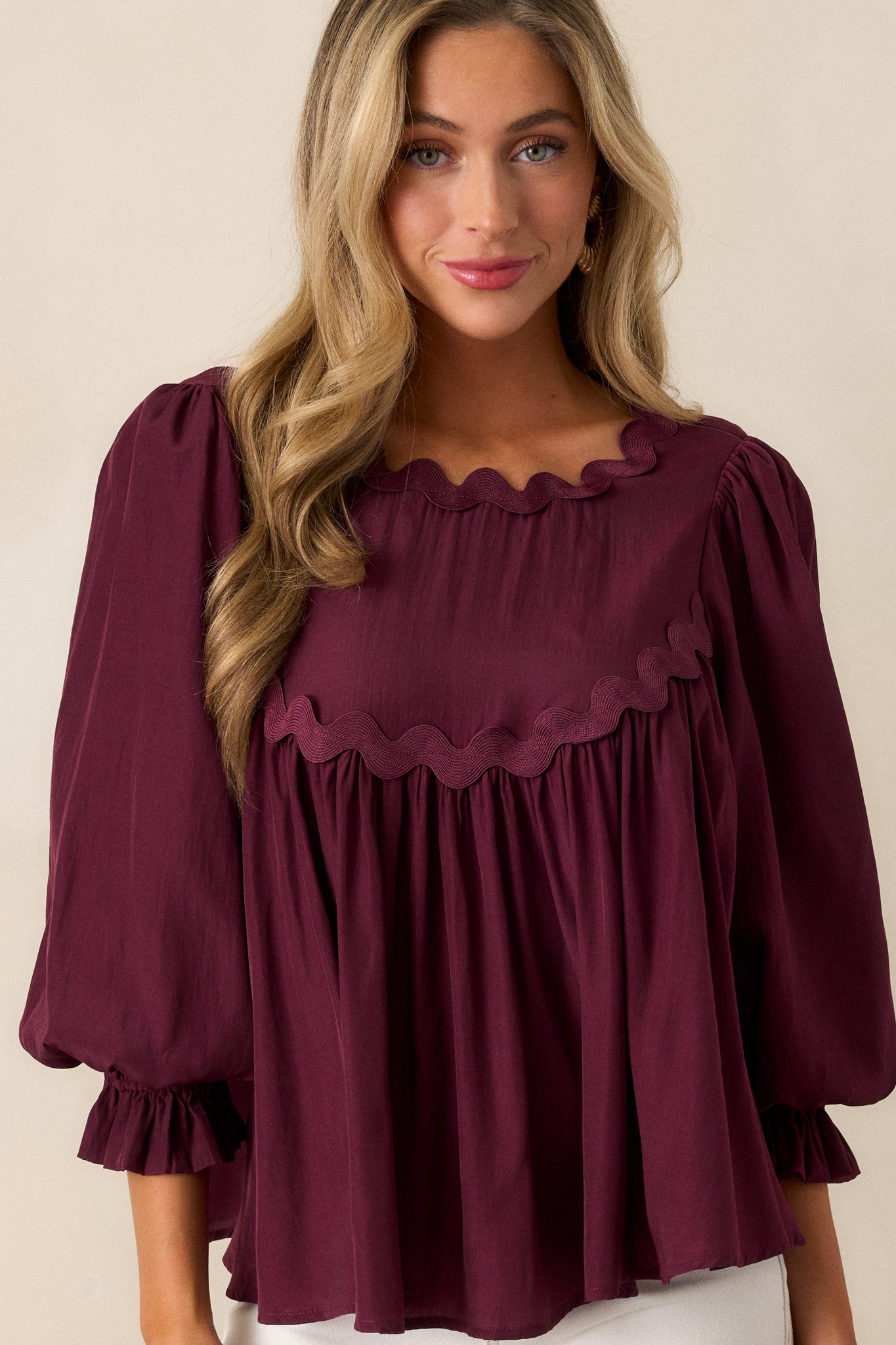 Detailed view of the scalloped yoke detailing on the dark sangria top, showcasing the intricate design and flowy fabric.