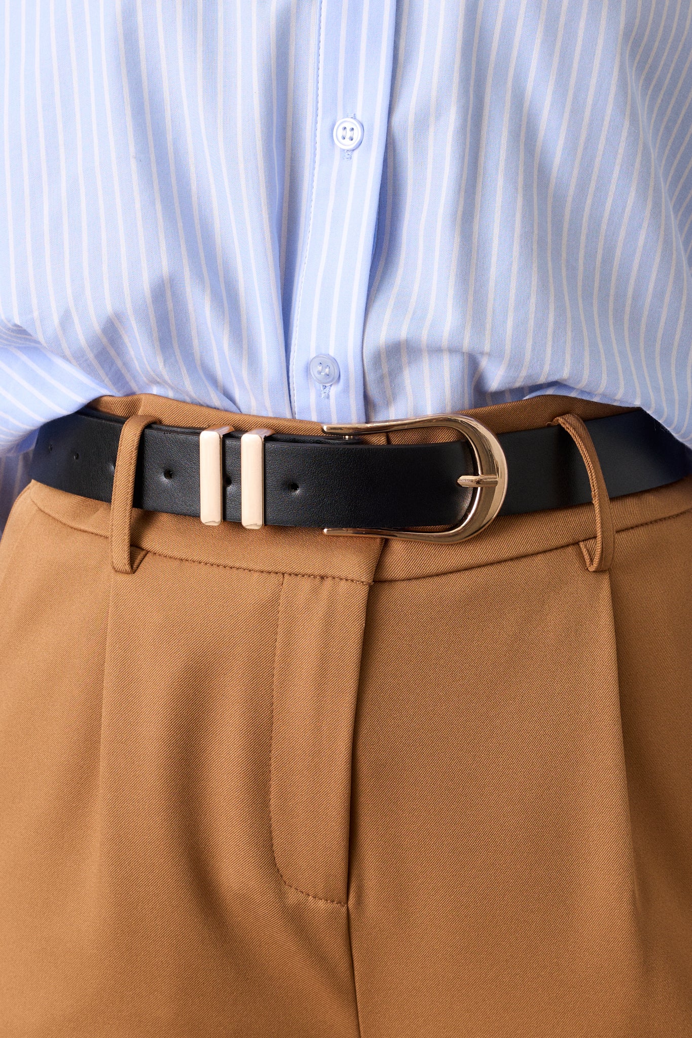 Detailed shot of the gold horseshoe pin buckle, showing the smooth black leather and metal texture.