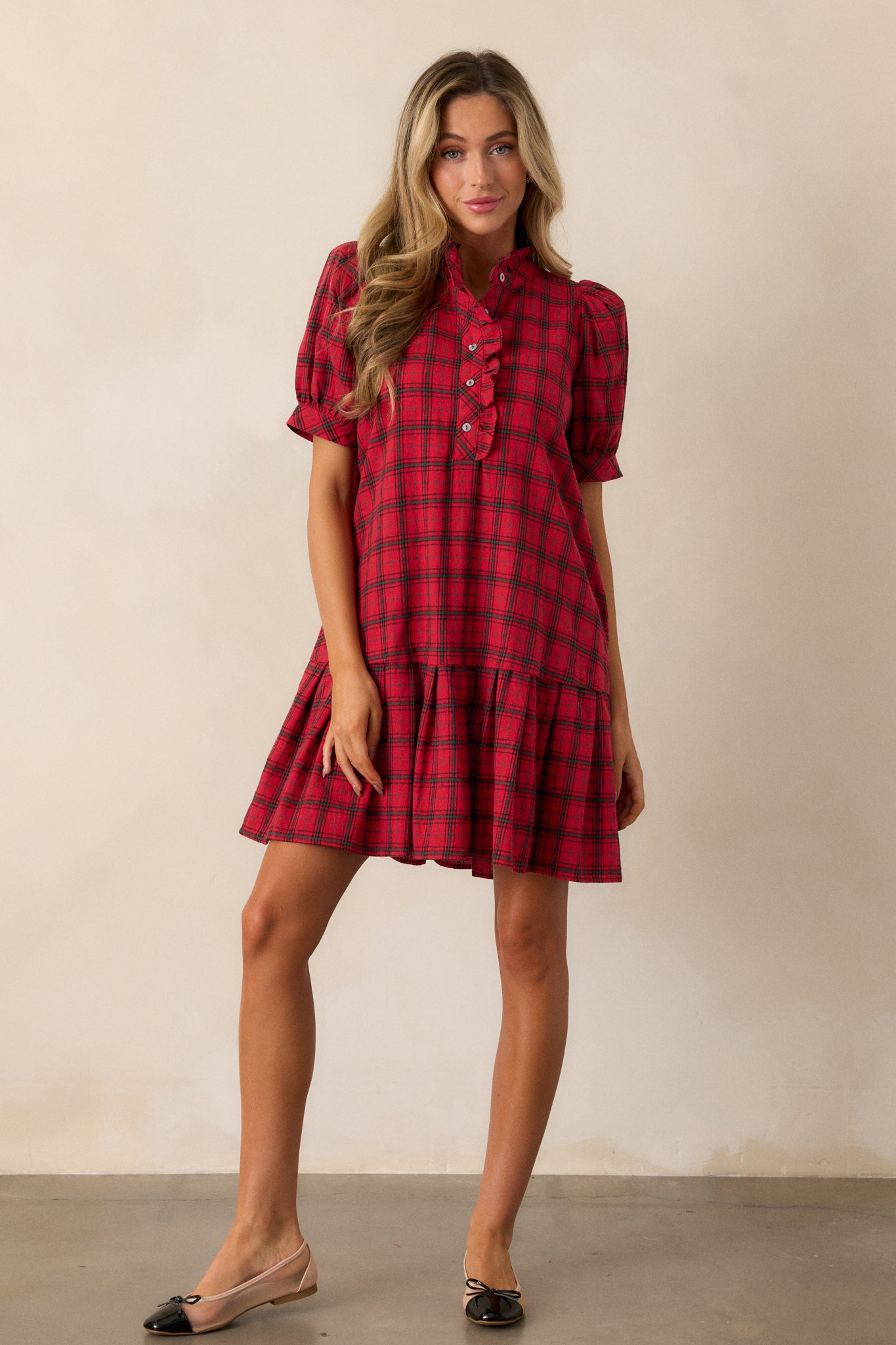 Full-length shot of the red dress, showcasing the puff sleeves, ruffled v-neckline, and plaid pattern with a flared silhouette.