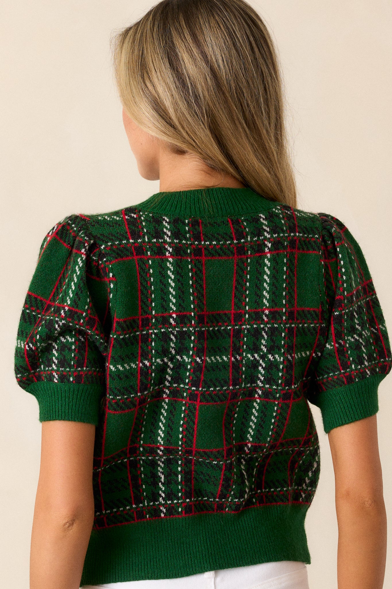 A back view of the sweater, showcasing the continuous plaid pattern and the relaxed, boxy fit from behind.