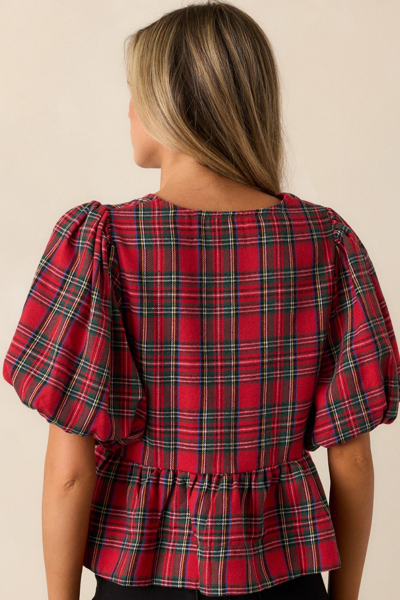 Back view of the red top, displaying the clean lines and structure, with a focus on the short puffer sleeves and the overall silhouette.





