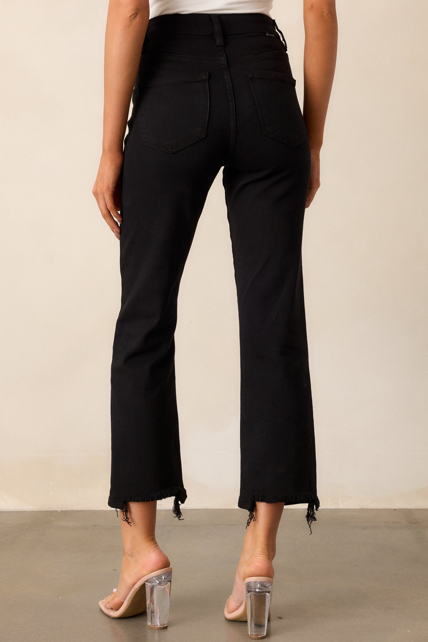  Back view of the black jeans, showcasing the functional back pockets and the high waist design, highlighting the fit and style from behind.