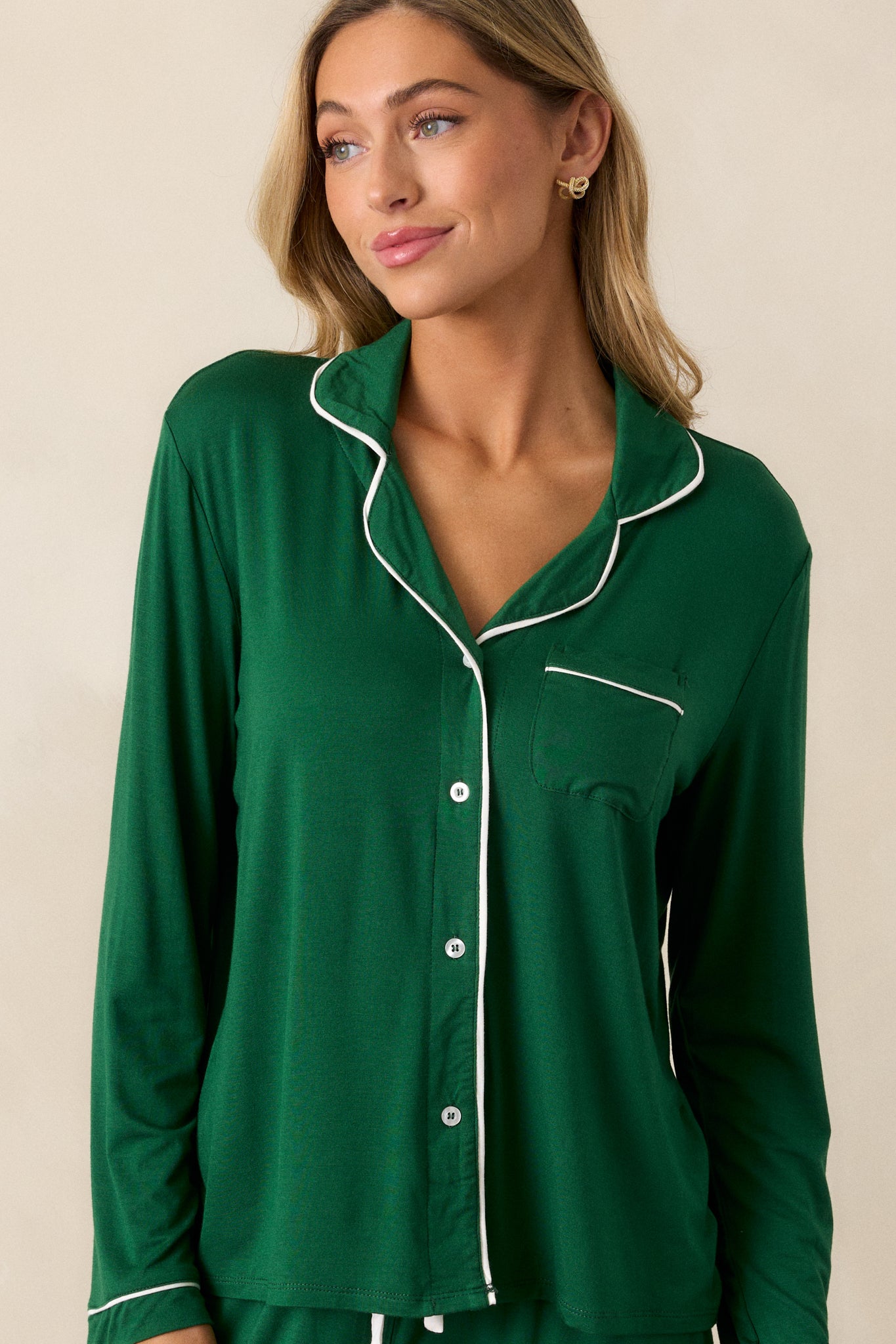 Front view of the pajama top, highlighting the white trim along the collar, button front, and front pocket, as well as the long sleeves with white-trimmed cuffs.