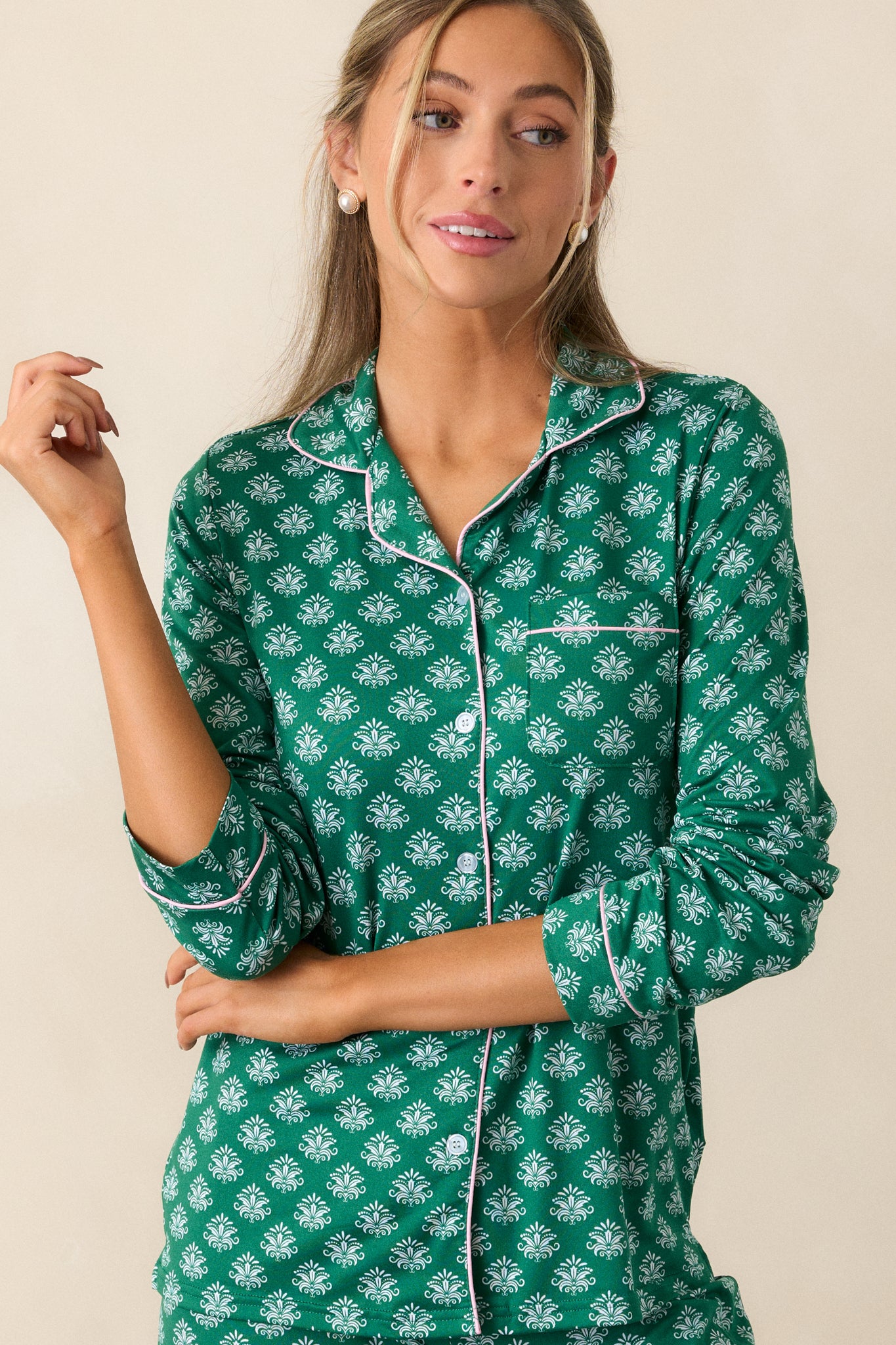 Detailed view of the front pocket with pink trim and Fleur de Lis pattern on the green pajama top.