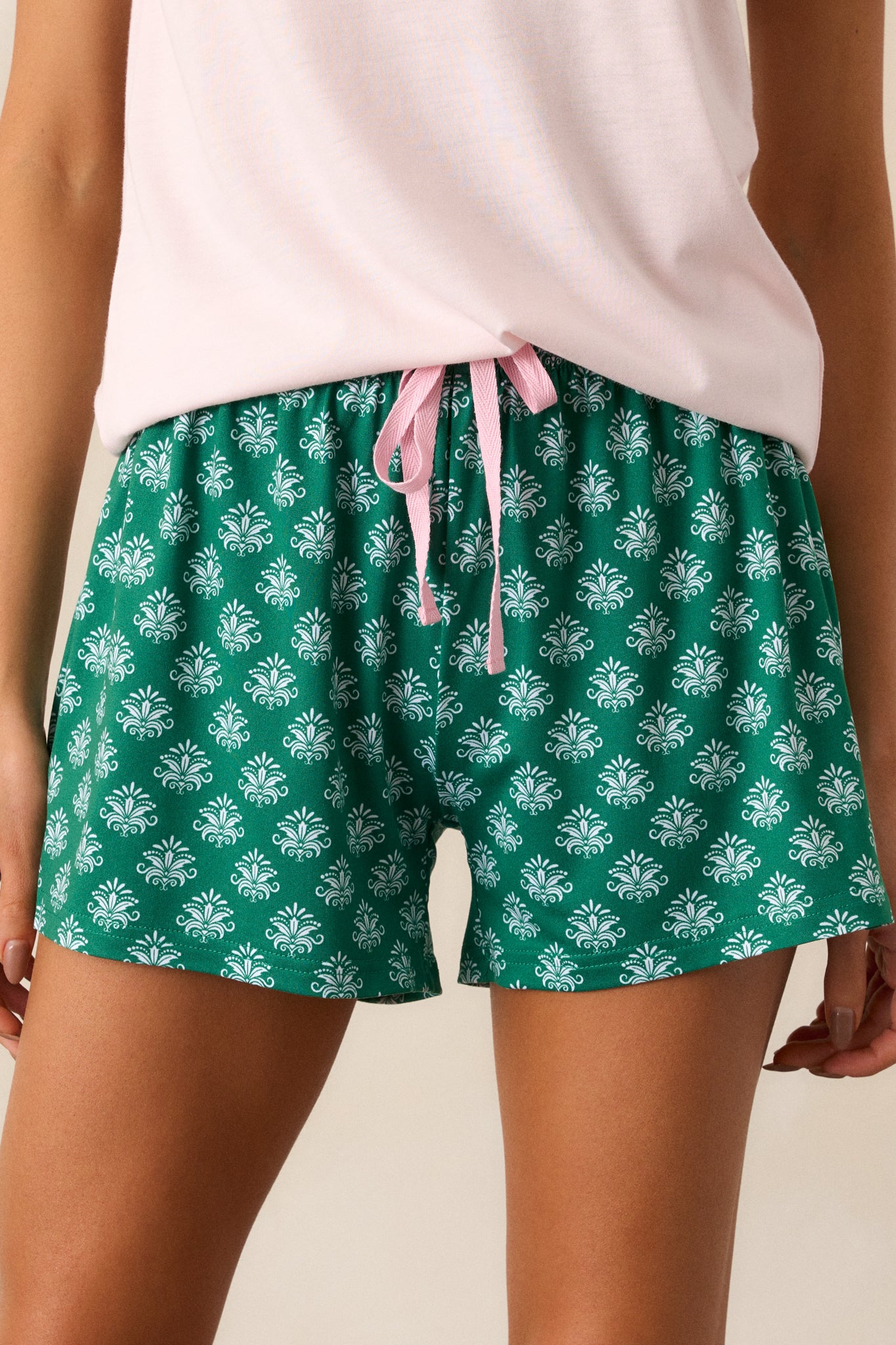 A cropped view of the lower section, focusing on the detailed Fleur de Lis pattern on the fabric and the loose fit around the legs.