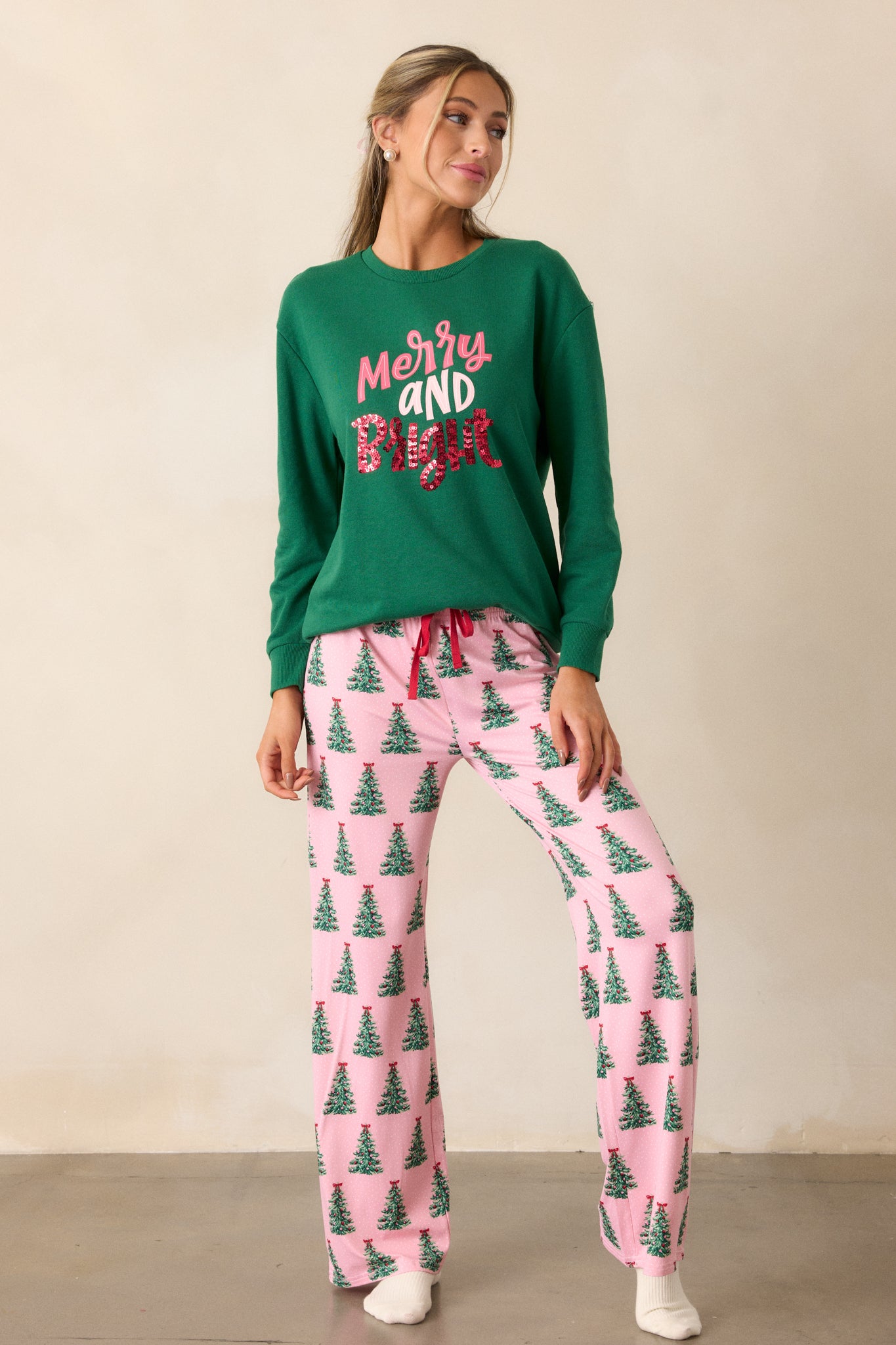 Full length view of the pajama pants, emphasizing the relaxed fit and how the white speckled polka dots complement the playful Christmas tree design.