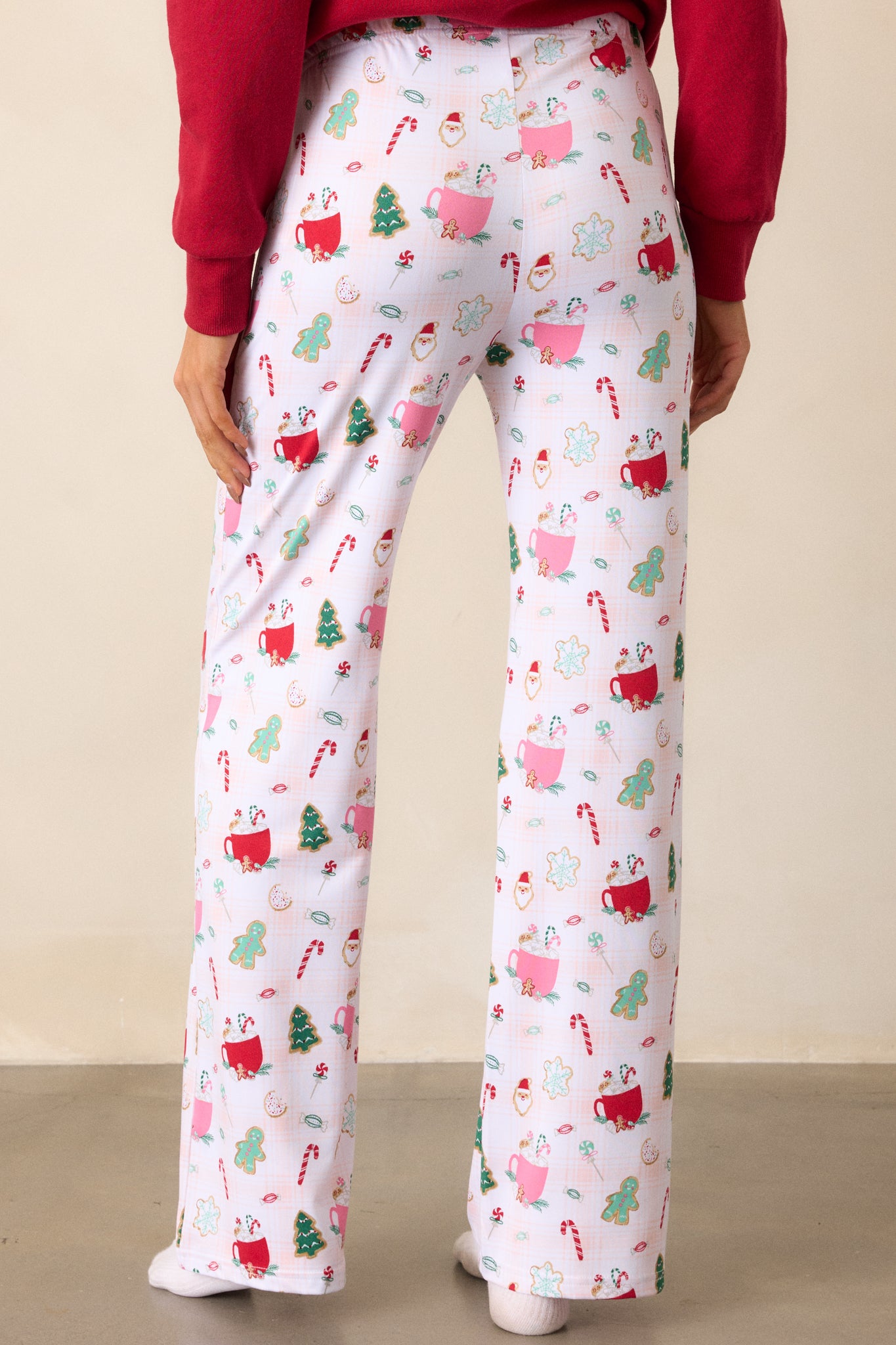 View of the back of the pajama pants, highlighting the continuation of the holiday print and the comfortable, relaxed fit with a focus on the plain back waistband.