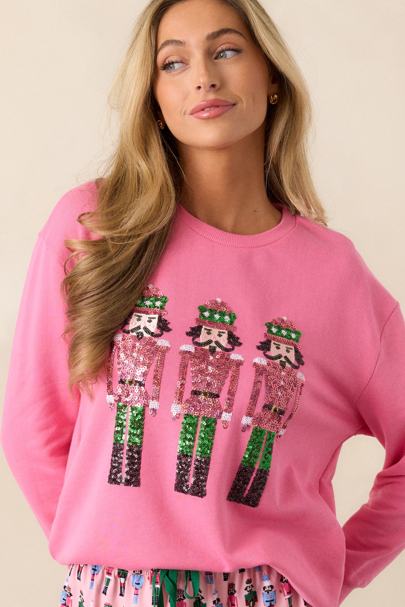 This pink sweatshirt features a crew neckline, sequin nutcracker design, a relaxed fit and long sleeves with ribbed hems.