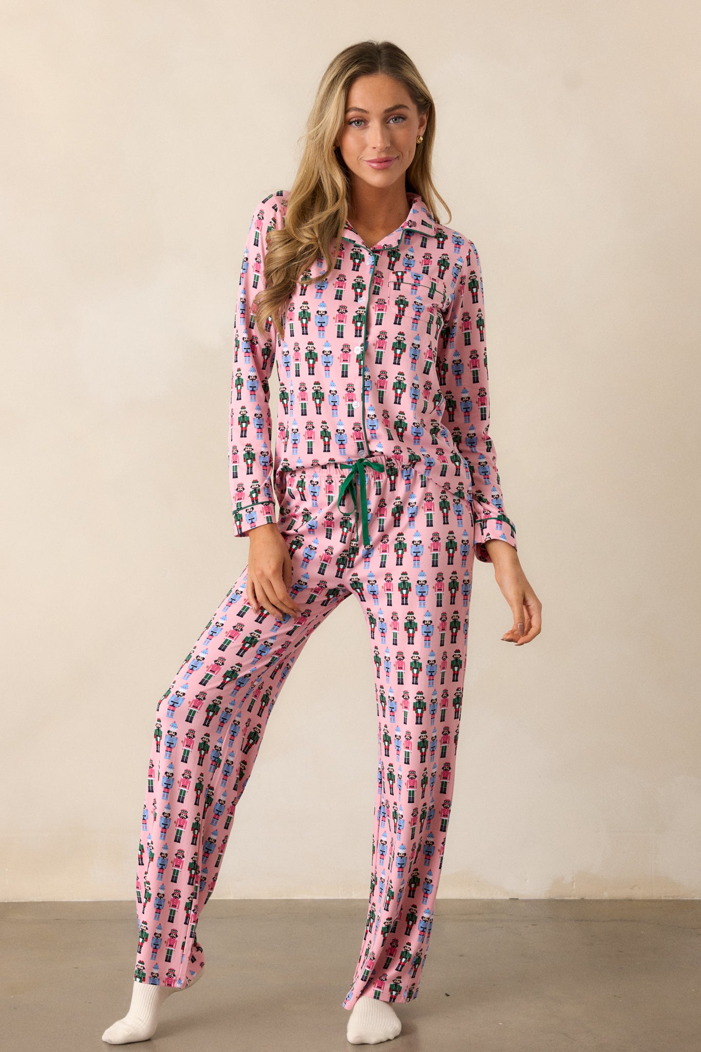 Front view of the pink pajama pants, displaying the all-over nutcracker print and loose, comfy fit.