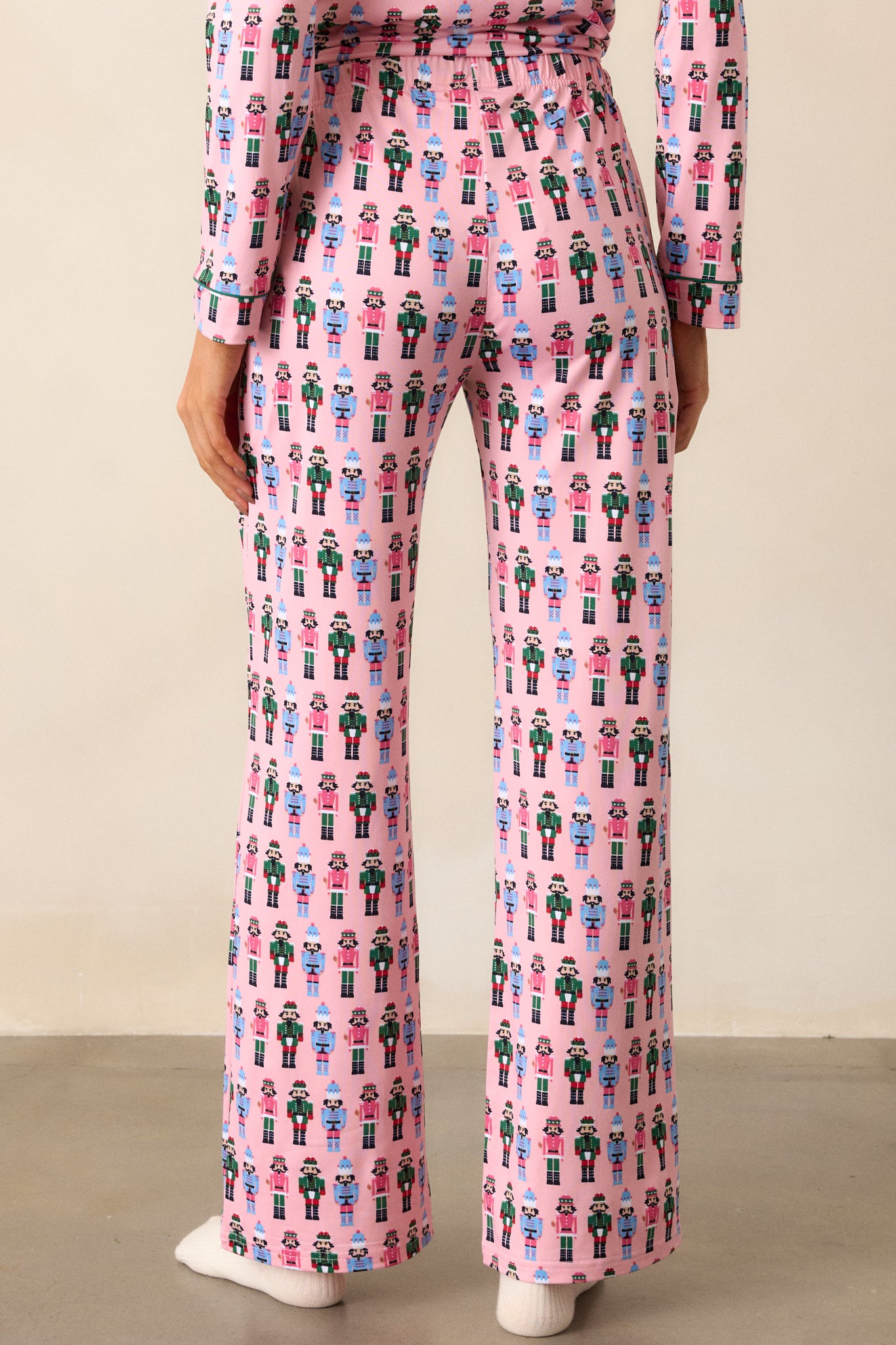 Back view of the pink pajama pants, showing the relaxed fit and full nutcracker print across the back.