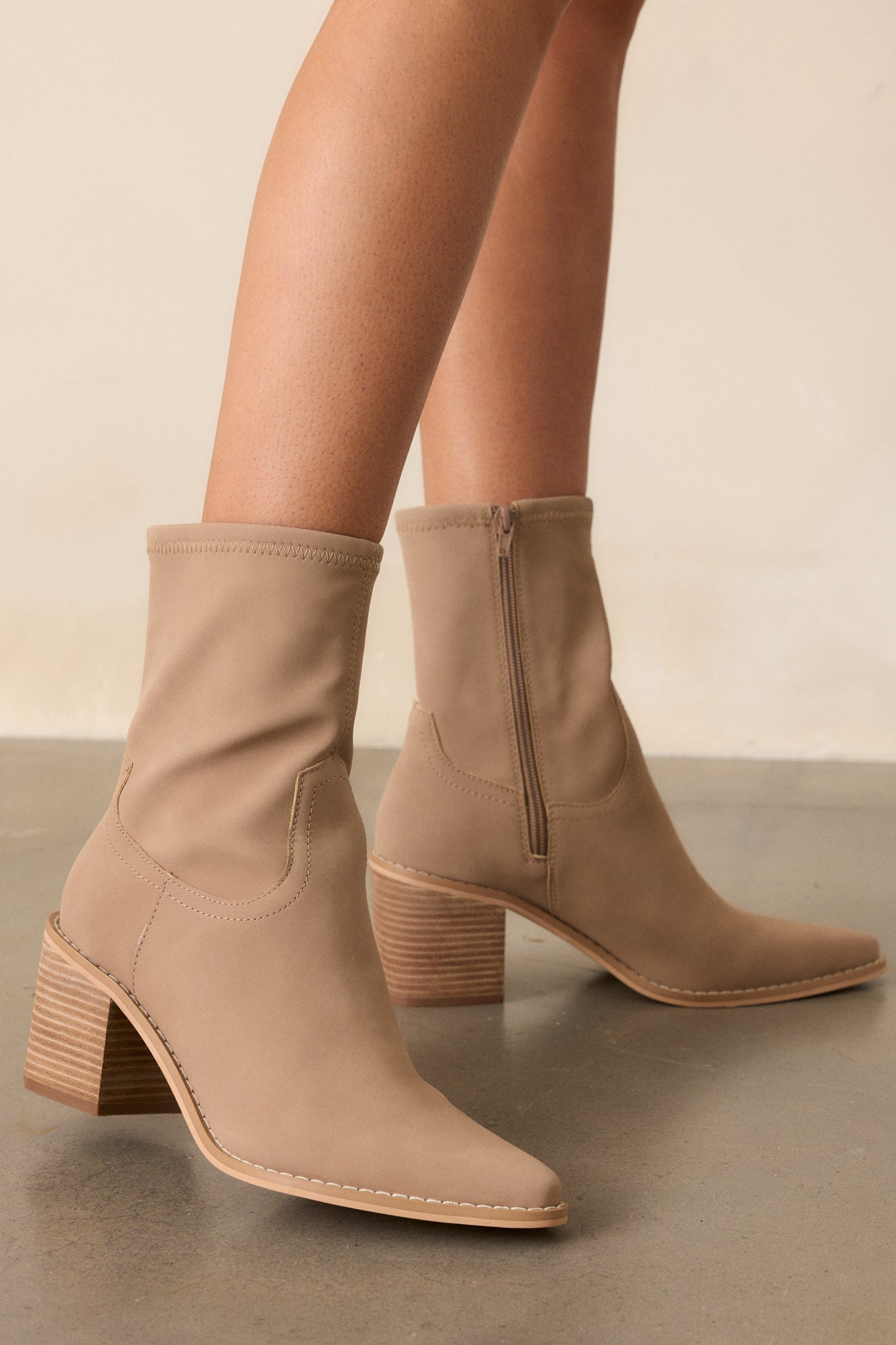 These taupe boots feature a pointed toe, a platform heel, a discrete side zipper and a tan sole.