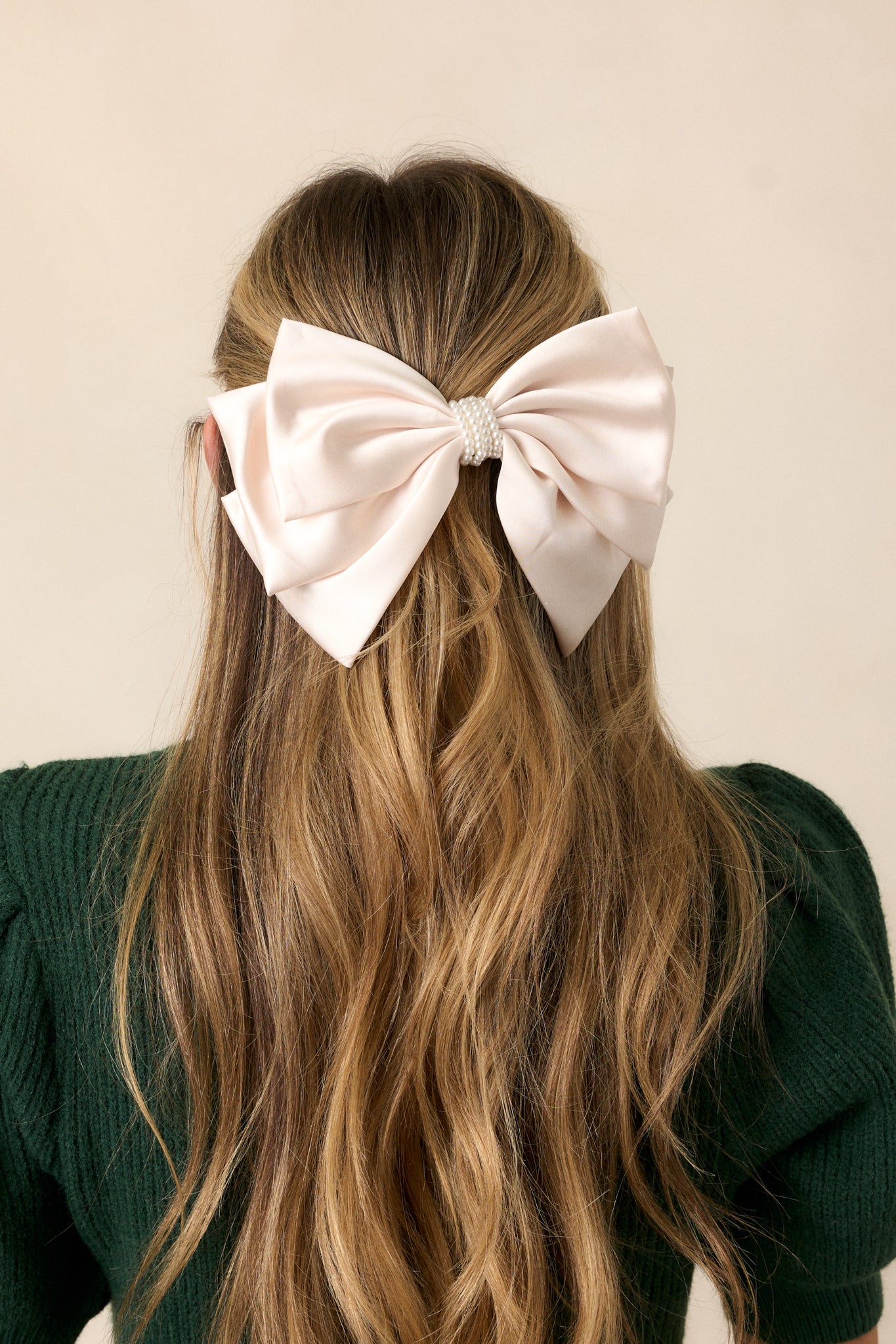 A cropped view of the ivory bow showcasing its multi-layer design, highlighting the elegant folds and the soft texture of the fabric.