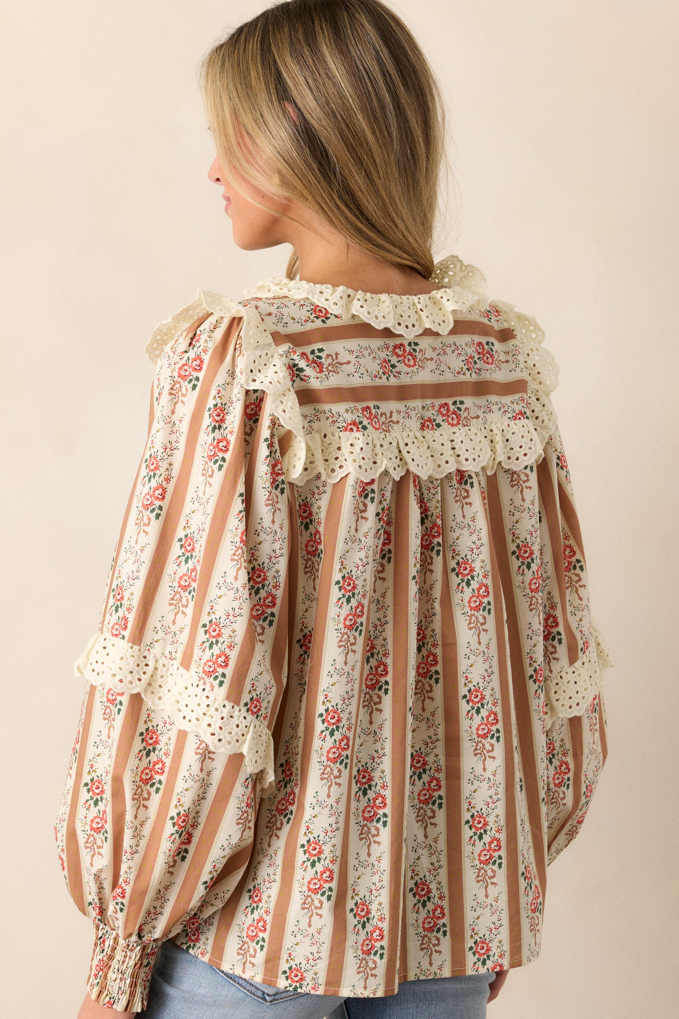 A rear view of the blouse, displaying the continuation of the stripe and floral pattern and highlighting the eyelet detailing around the shoulders.