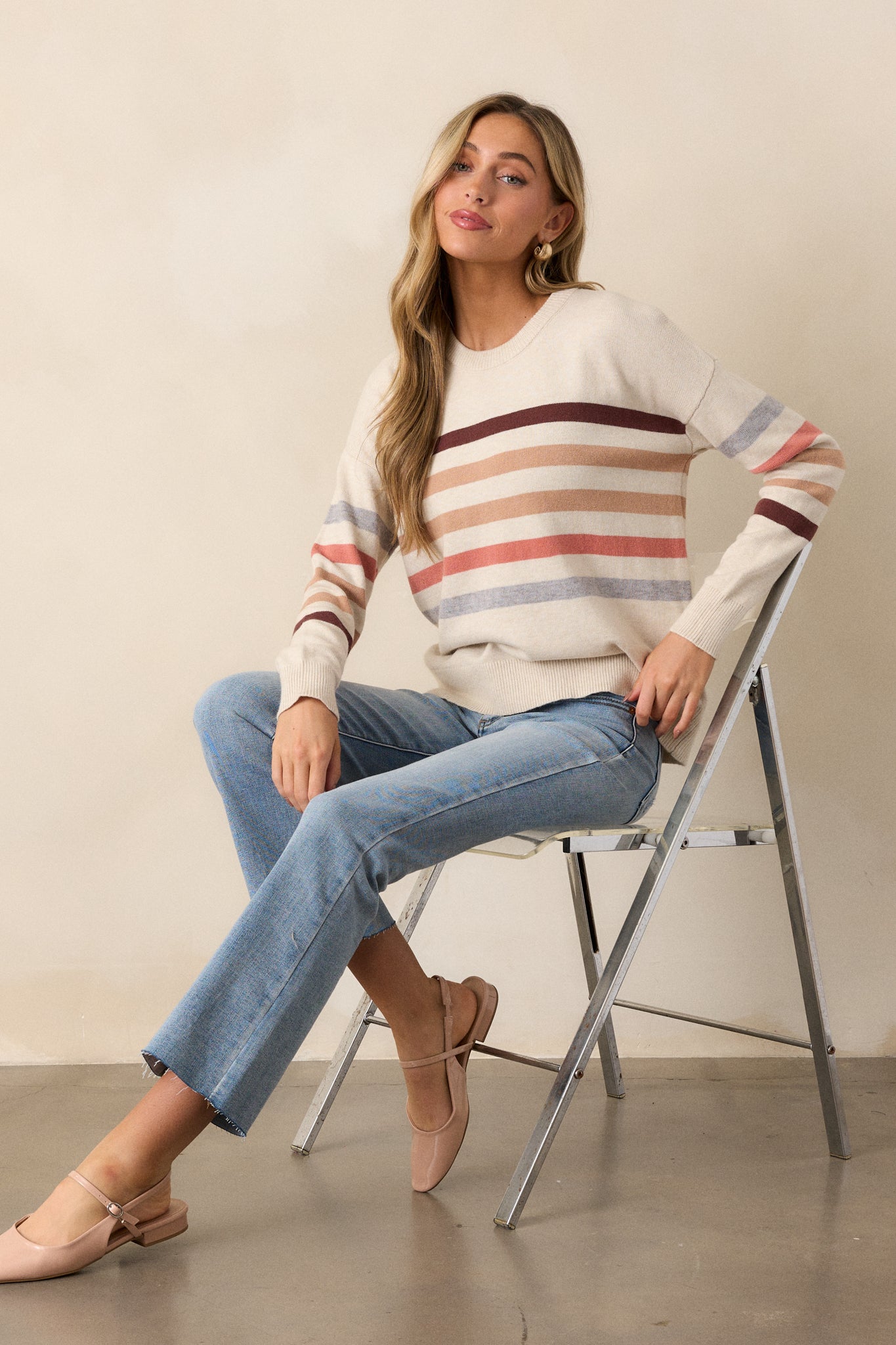 Full-length view of the beige stripe long sleeve sweater, showing the horizontal stripe pattern and ribbed hem extending to the waist.