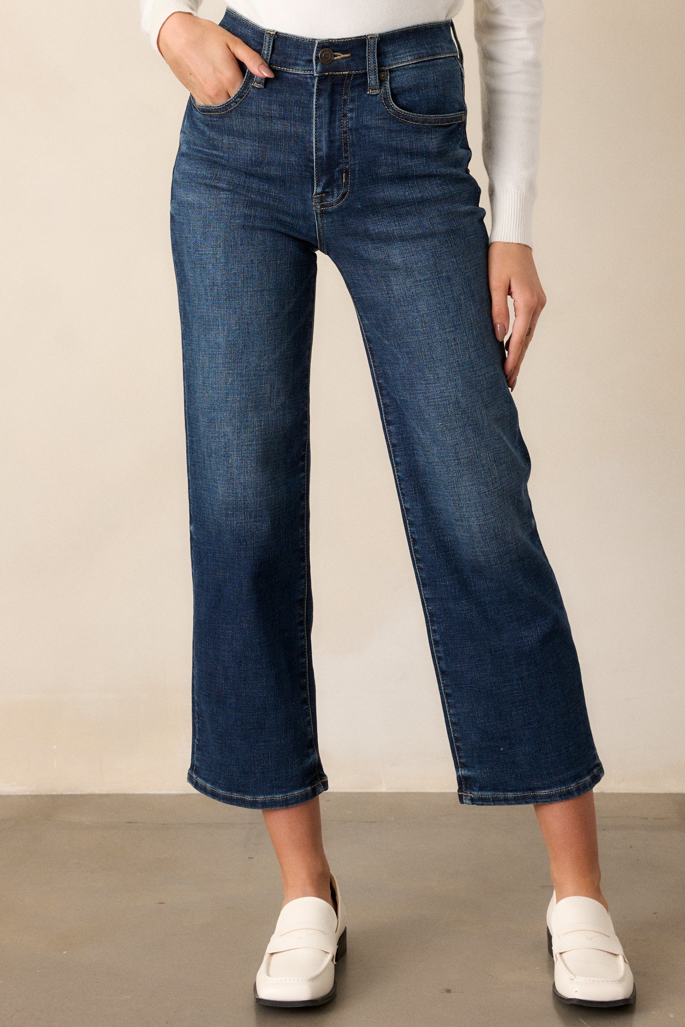 Close-up of the upper section of the jeans, emphasizing the high waist and functional front pockets with a button and zipper closure.