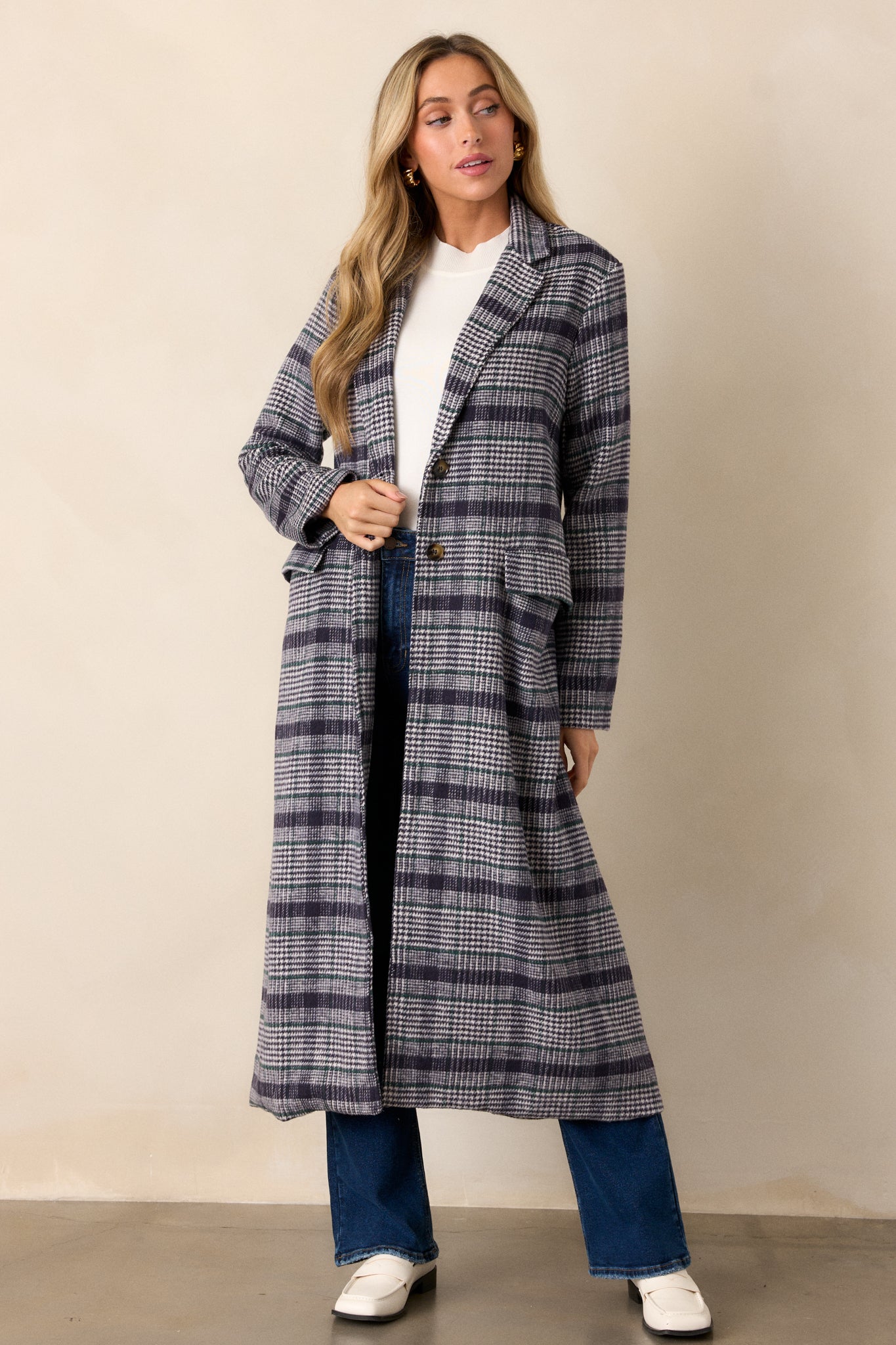 A front-facing view of the navy plaid coat, highlighting the lapel collar, button front closure, and midi-length design.