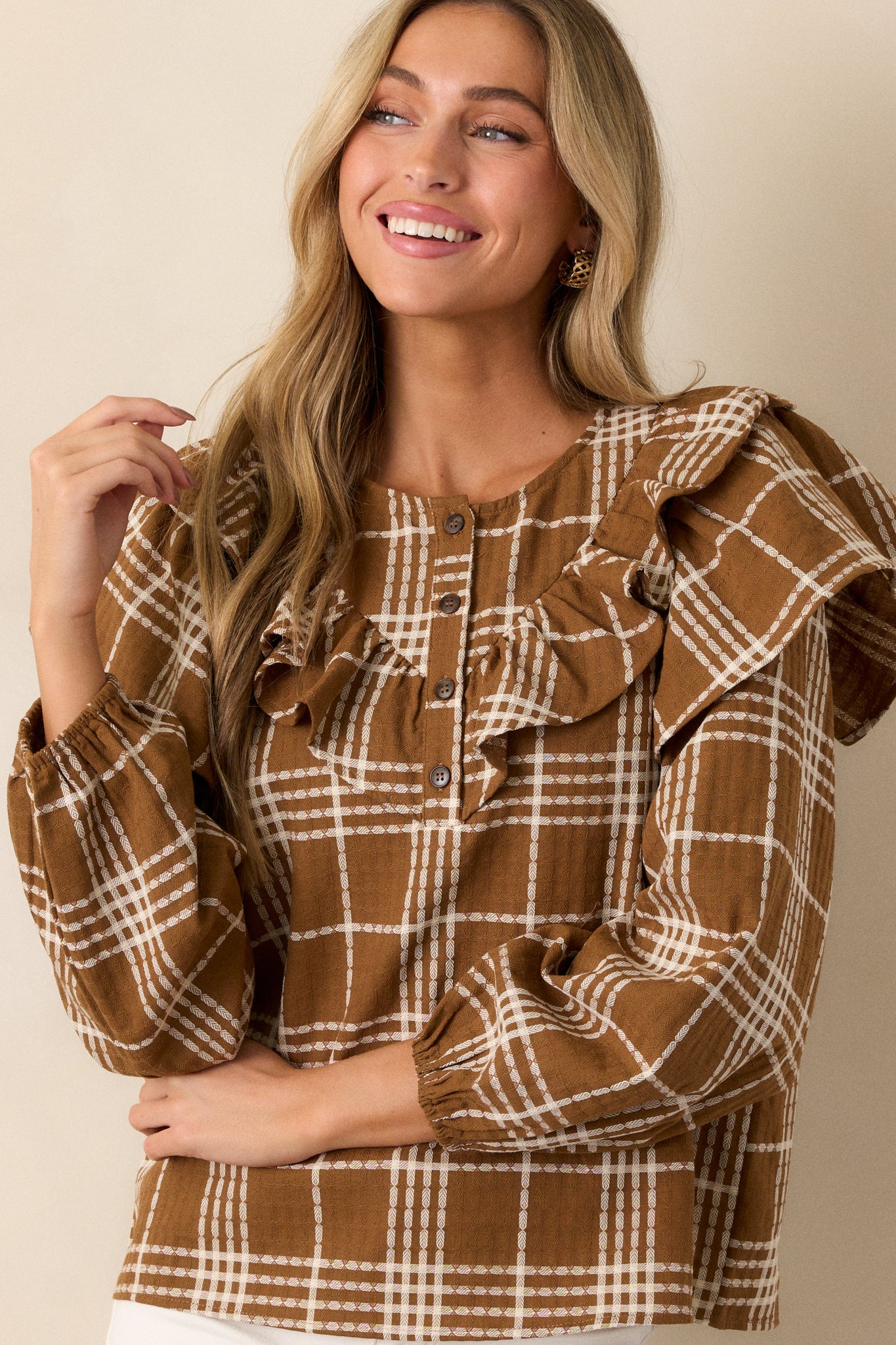 The blouse displayed from the front, emphasizing the ruffle detailing along the front and shoulders and the boxy fit.