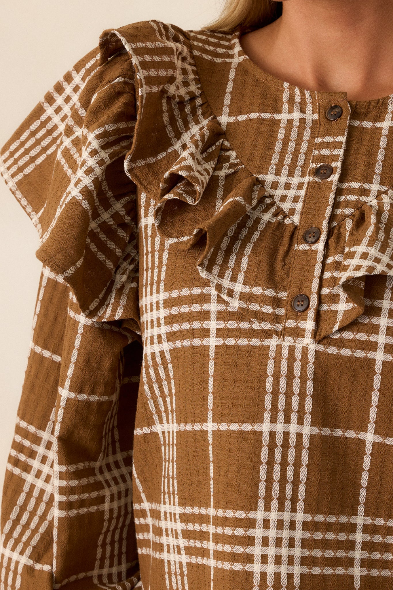 A zoomed-in shot of the button placket and ruffle detailing, highlighting the intricate design and texture of the fabric.