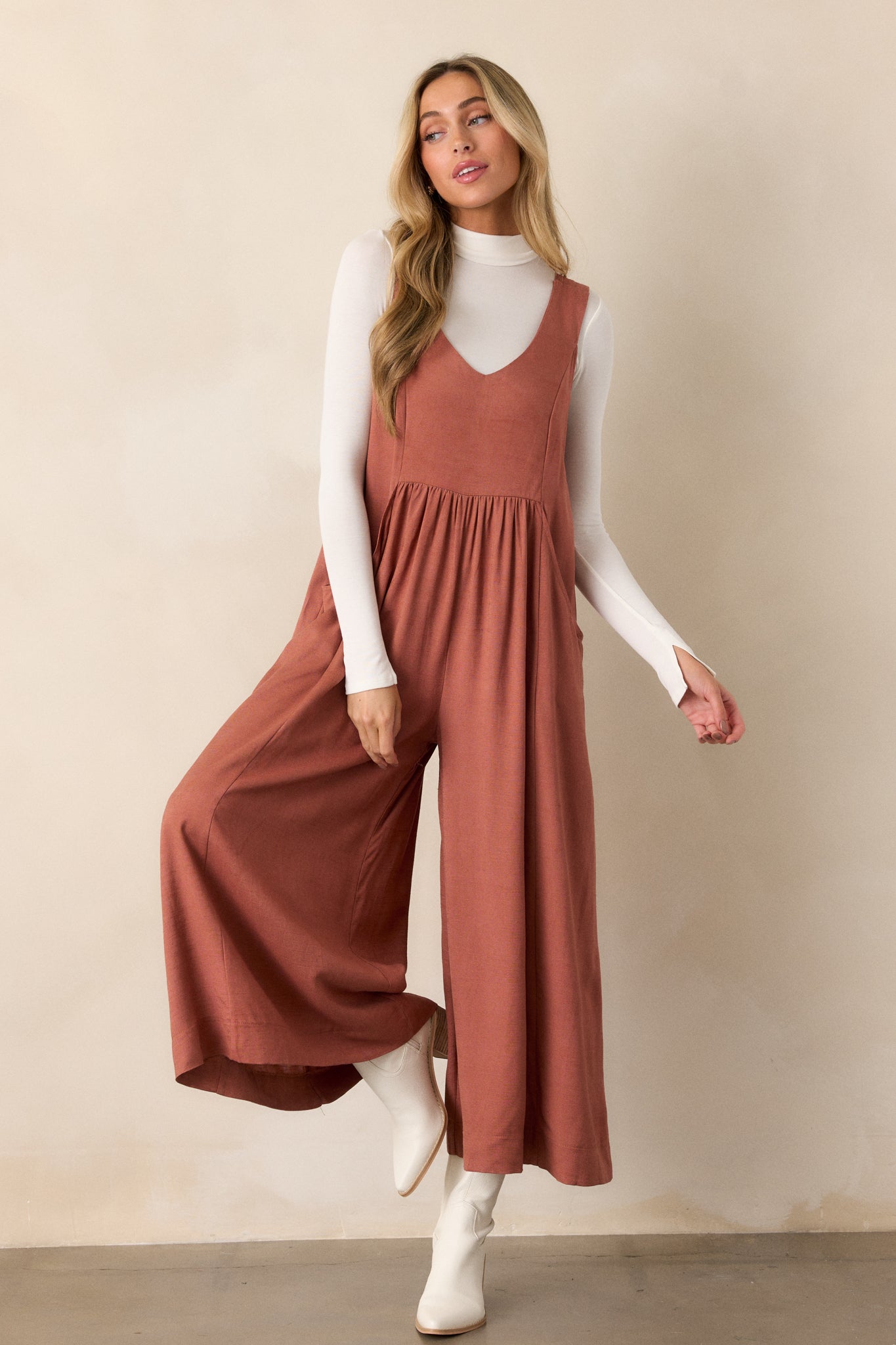 The jumpsuit displayed from a slight angle, emphasizing the functional pockets and the overall relaxed fit, allowing the fabric to drape beautifully.