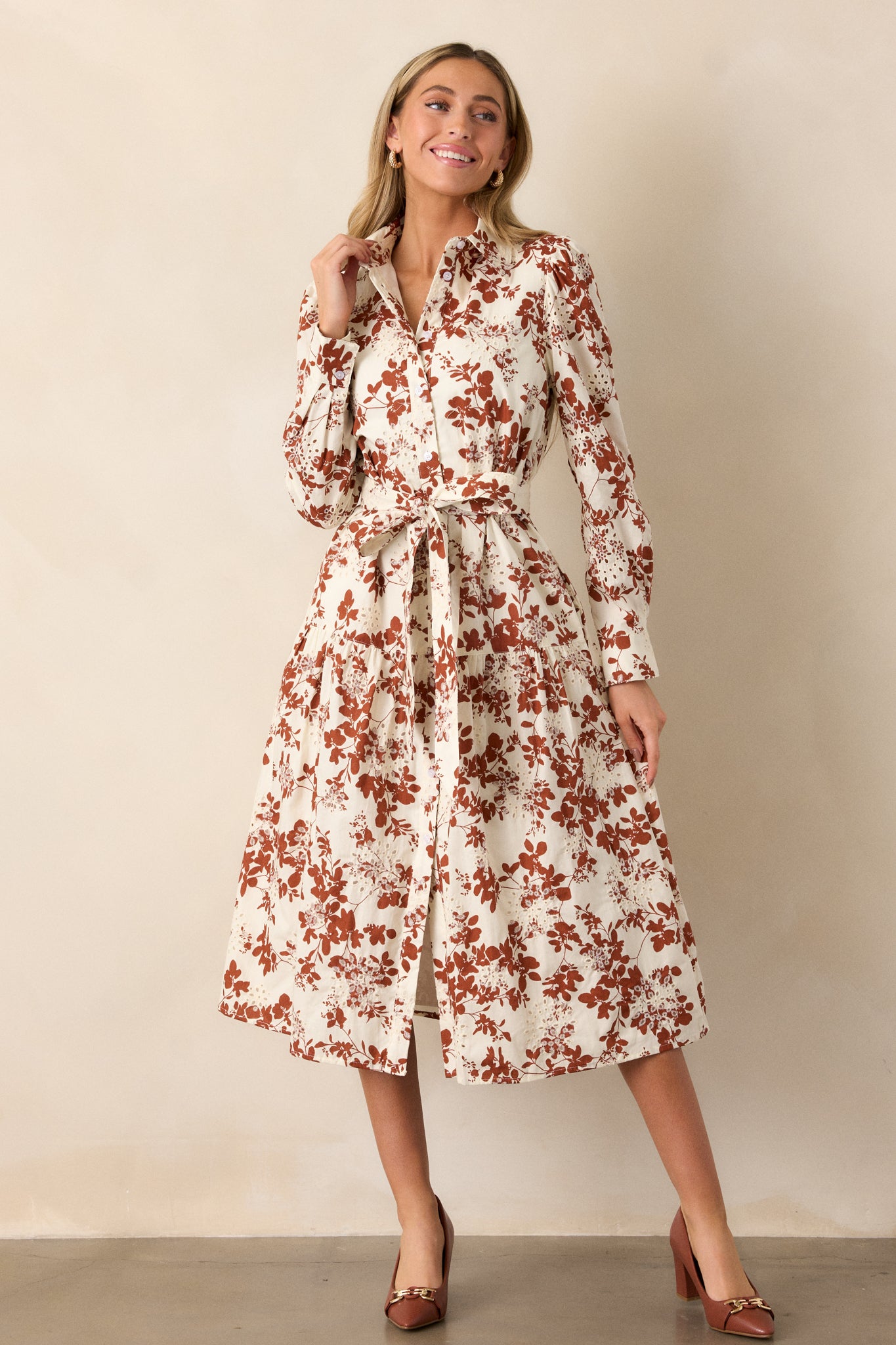 The dress shown from the front, emphasizing the functional button front and the intricate eyelet detailing along the hem and sleeves.