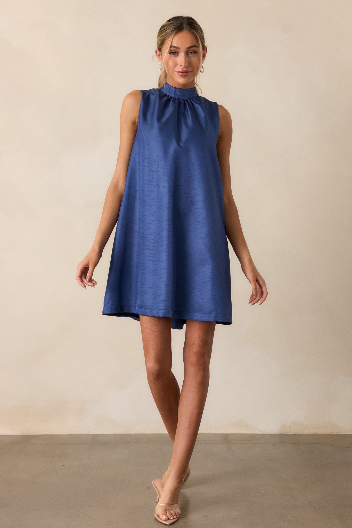 A royal blue dress featuring a high neckline and sleeveless design, showcasing a shift silhouette that flows elegantly.