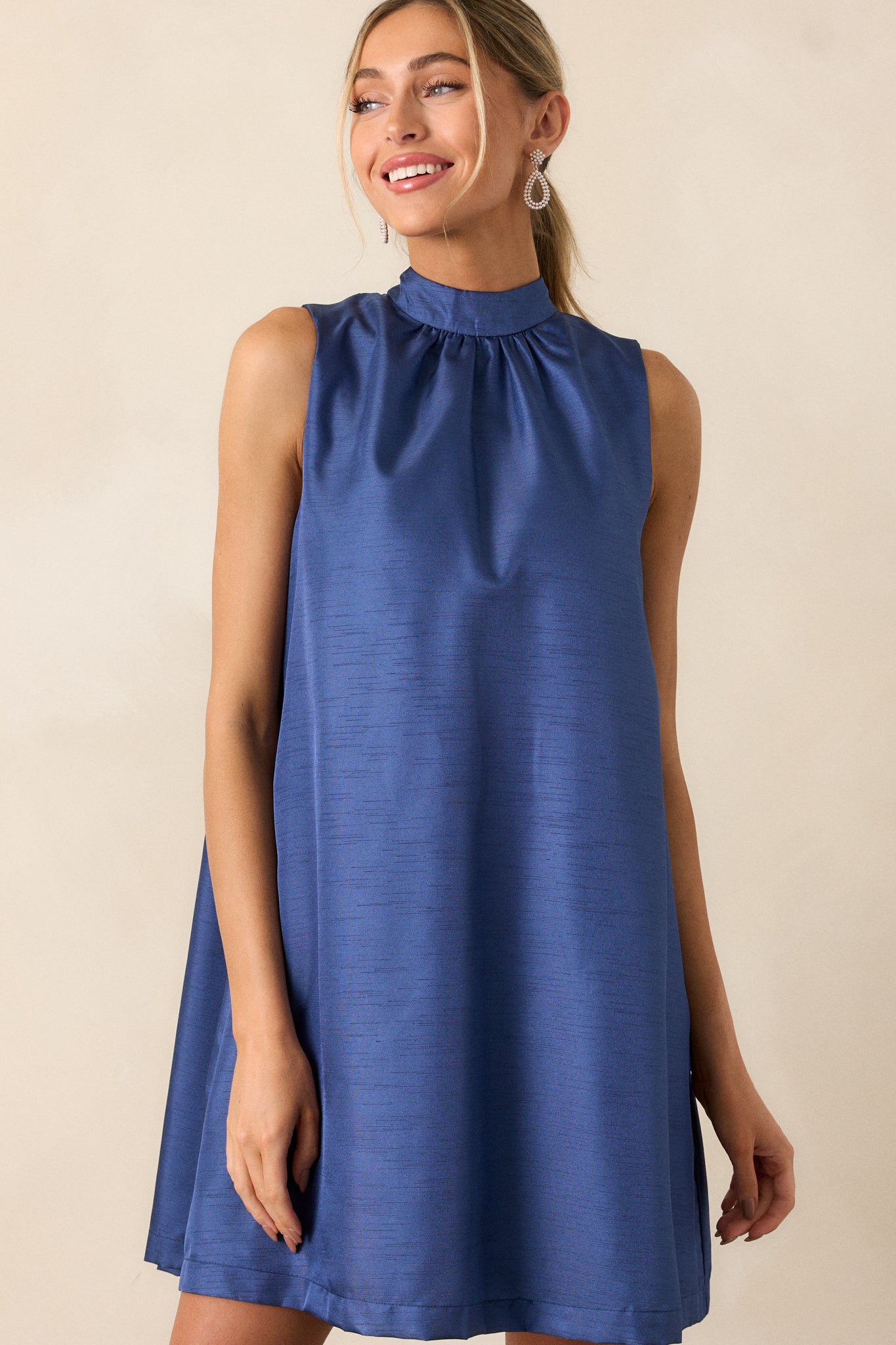 Close-up of the high neckline of the royal blue dress, showcasing the clean lines and elegant design.