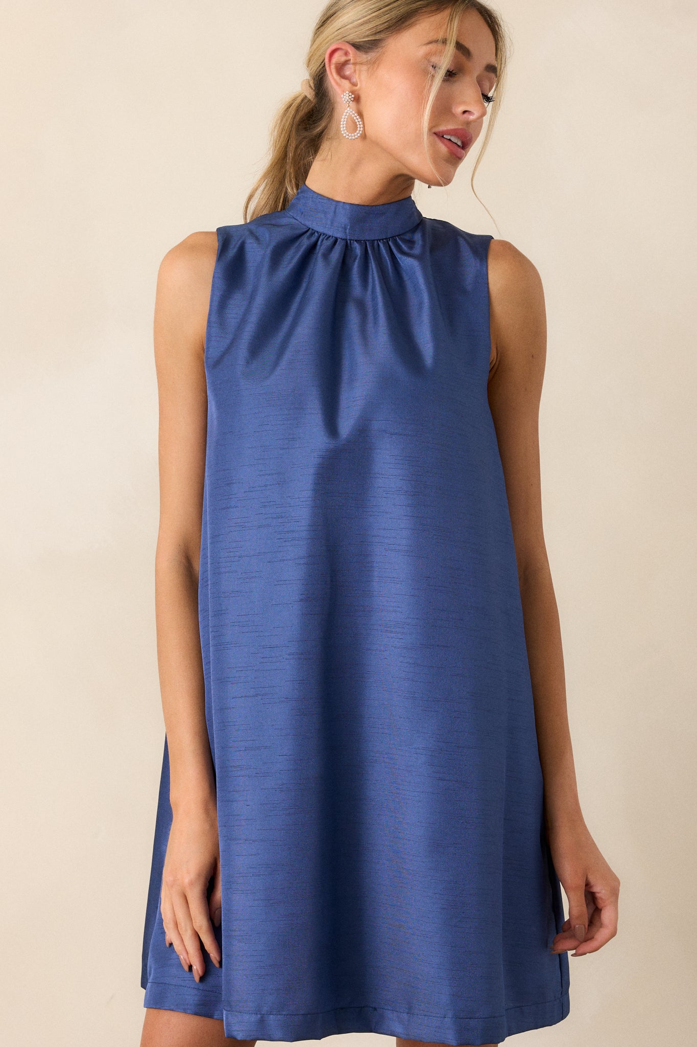 Detailed shot of the armholes and shoulder area of the sleeveless royal blue dress, highlighting the smooth transition into the shift silhouette.