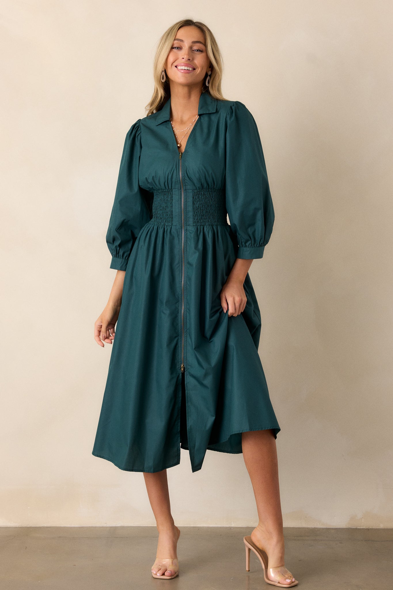 Full-length view of the dress from an angle, focusing on the structured collar, v-neckline, and 3/4 sleeves with cuff detail.